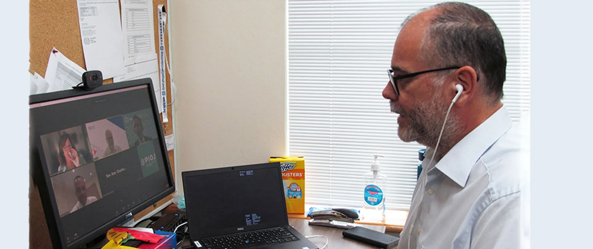 Photo of a man looking at a monitor view a virtual meeting