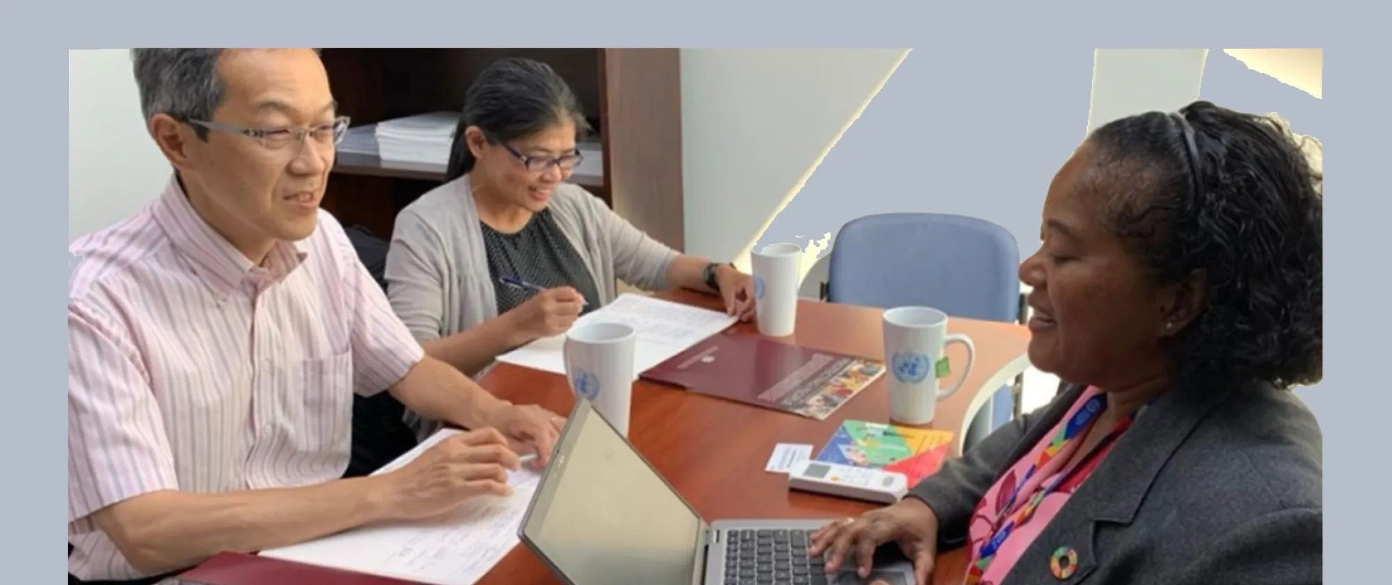 Three people having a discussion around a table