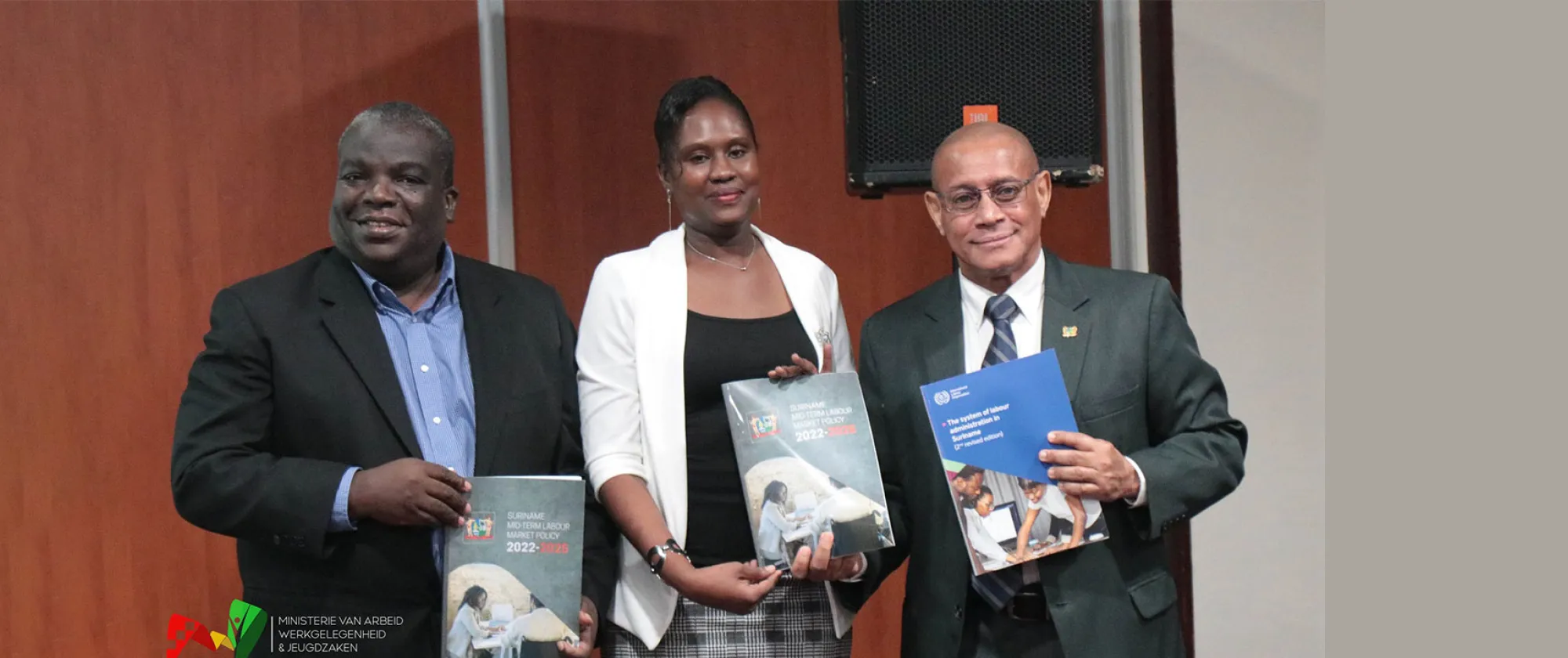 Three people standing holding a report