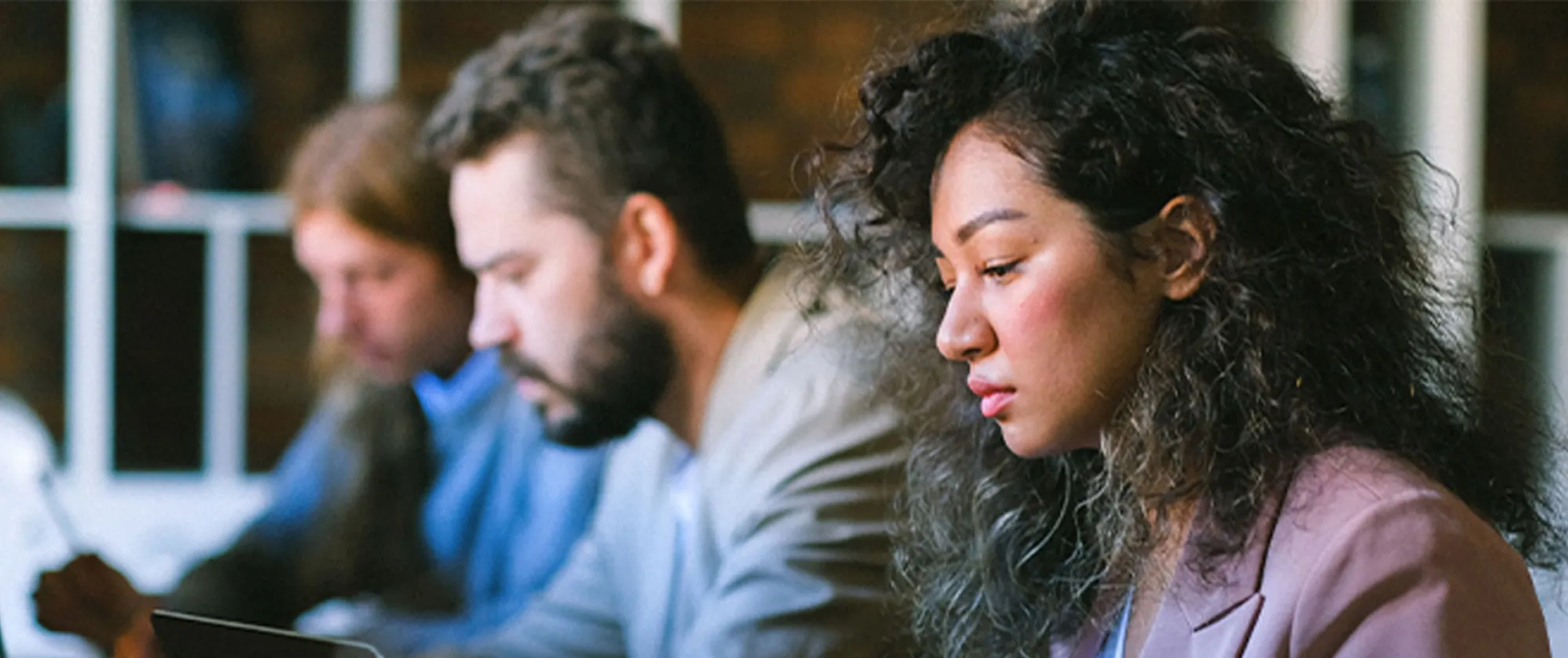Three people looking down at laptop screens