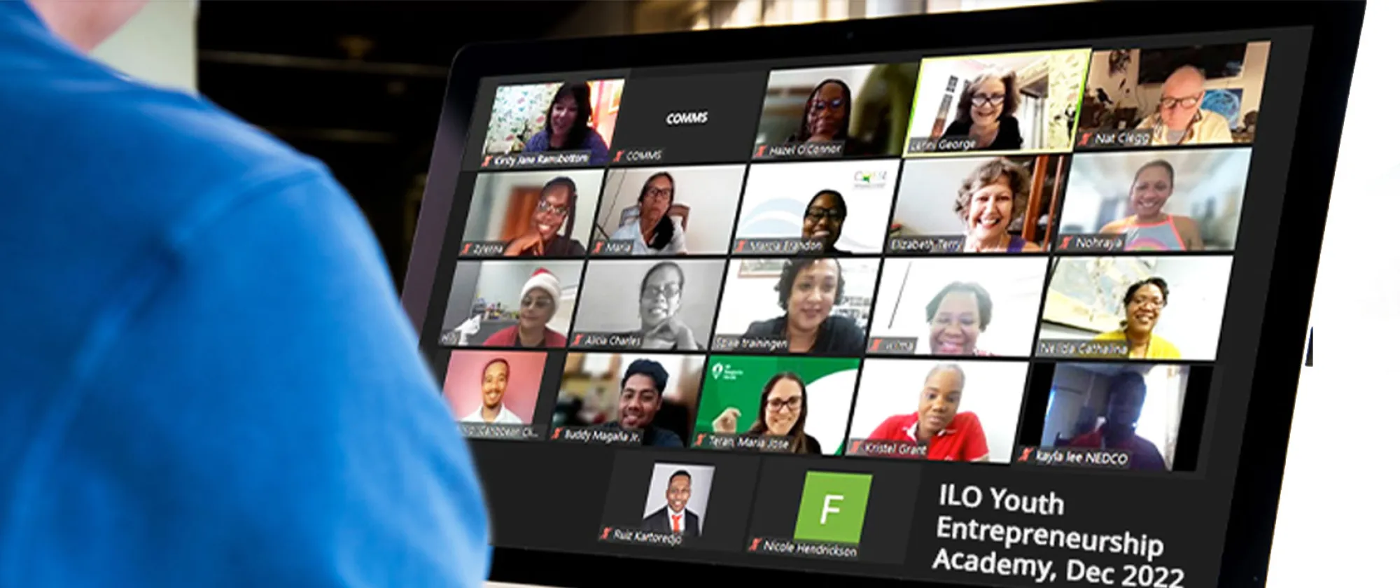 Man looking at participants of a virtual meeting on a desktop monitor