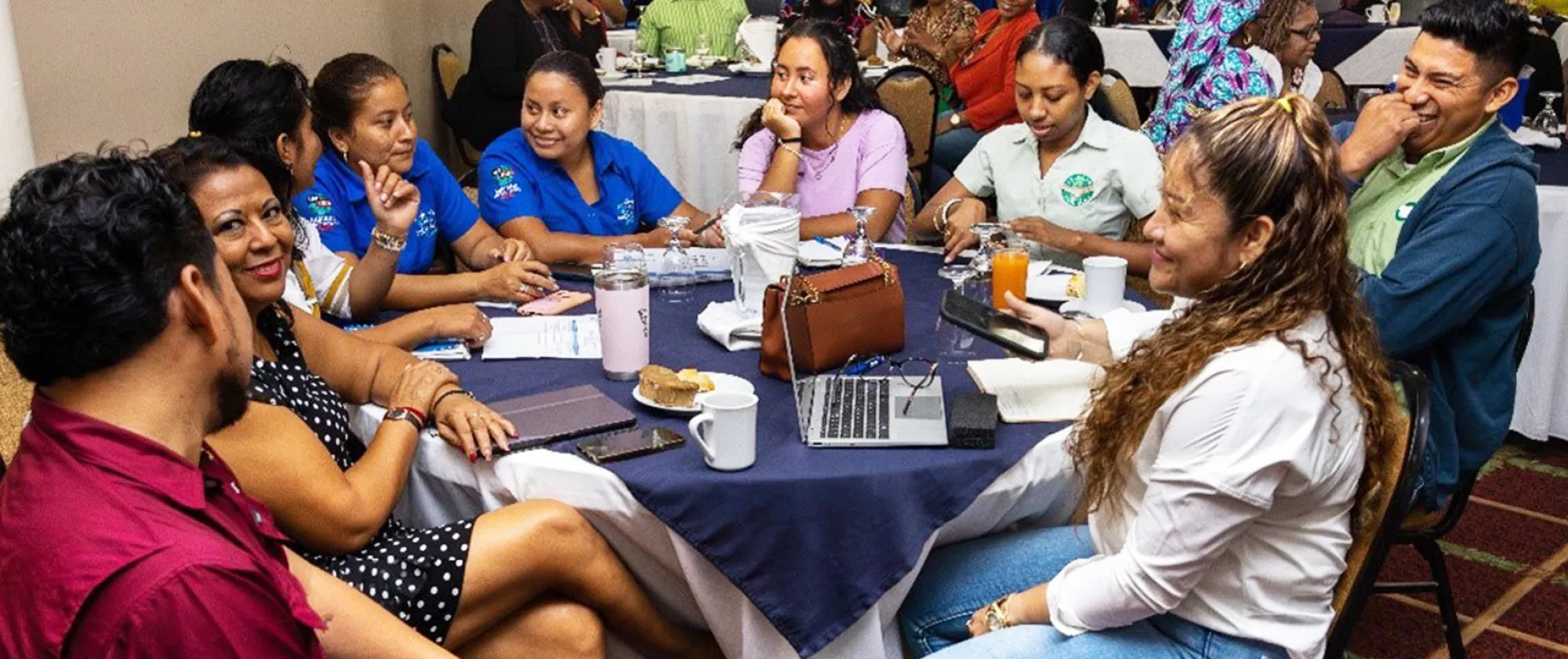 A group of people sitting around a table talking and laughing