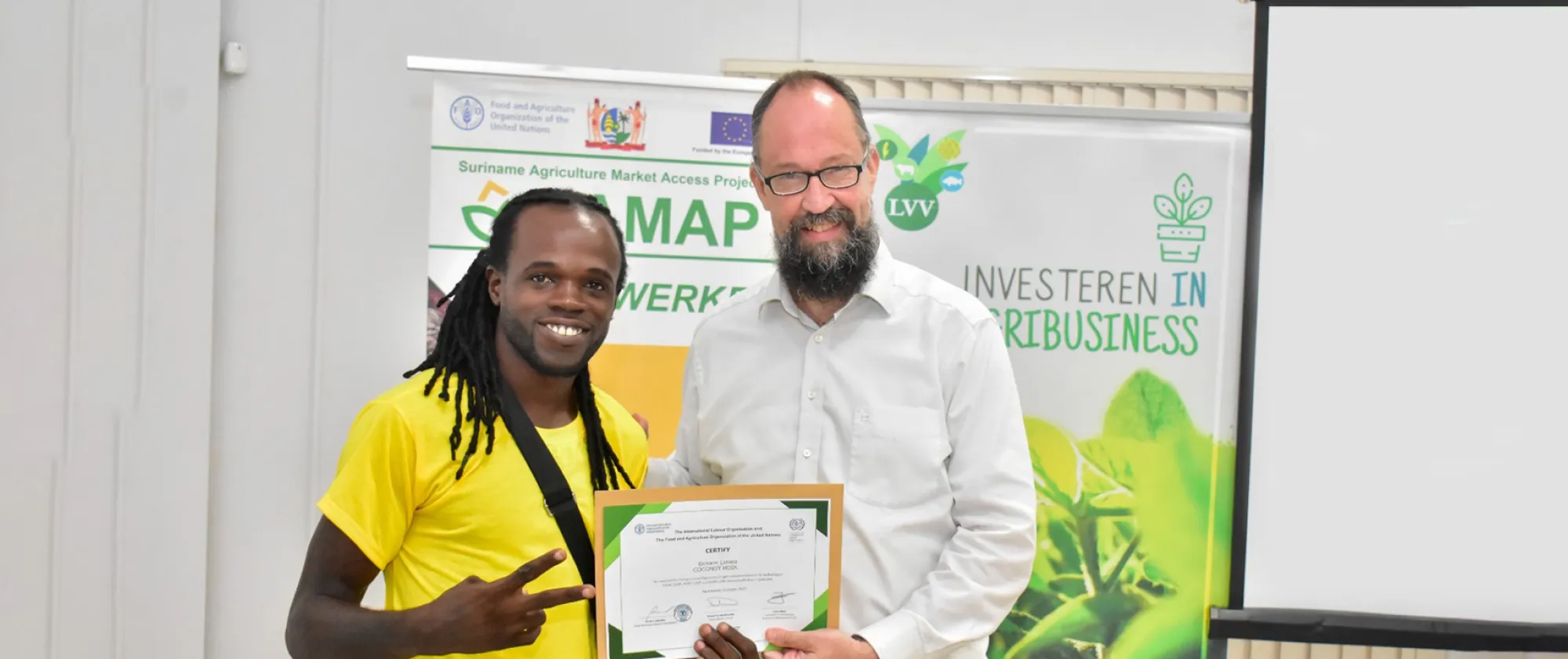Photo of ILO official John Bliek handing a training certificate to Giovanni Liveweld 