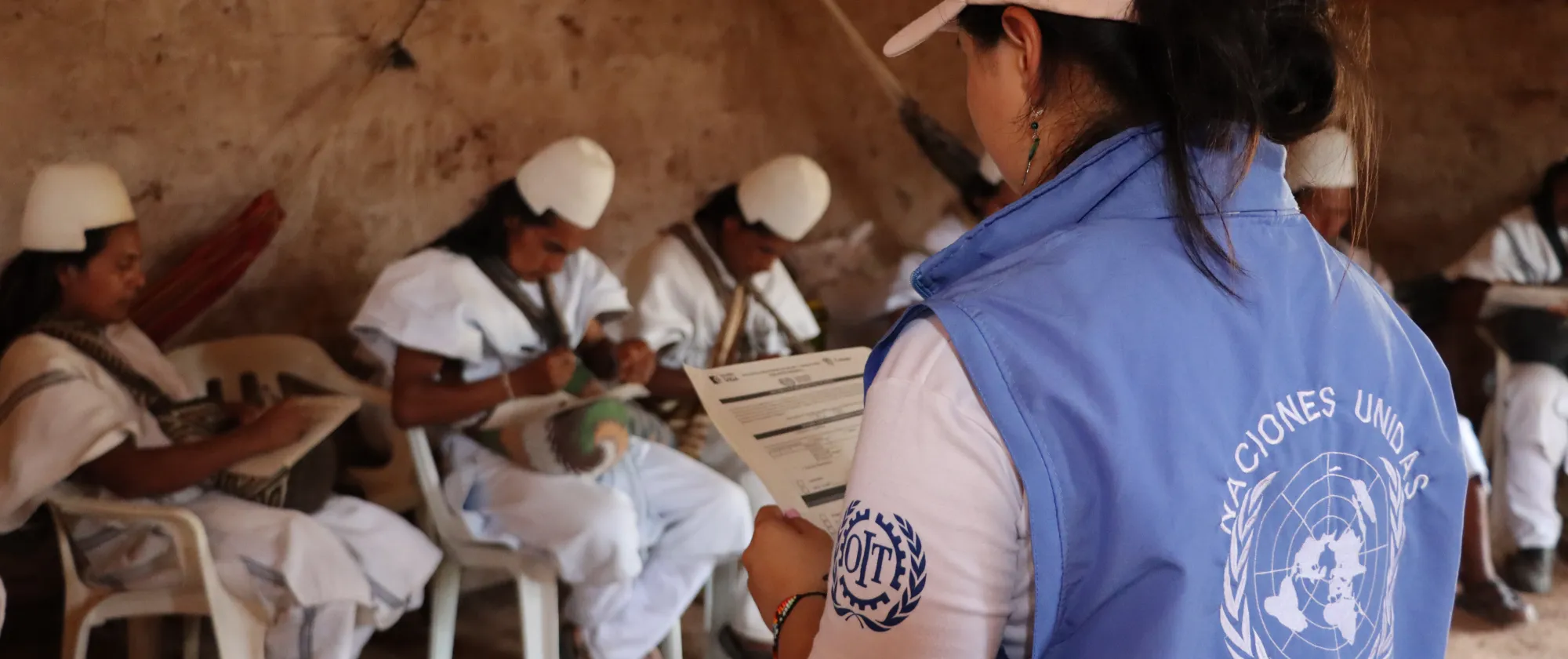 Funcionaria de OIT junto con miembros del pueblo indígena Arhuaco revisando una encuesta de seguridad y salud en el trabajo