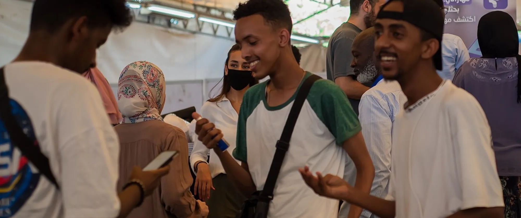 People conversing at a tent, engaged in lively discussions and exchanging ideas.