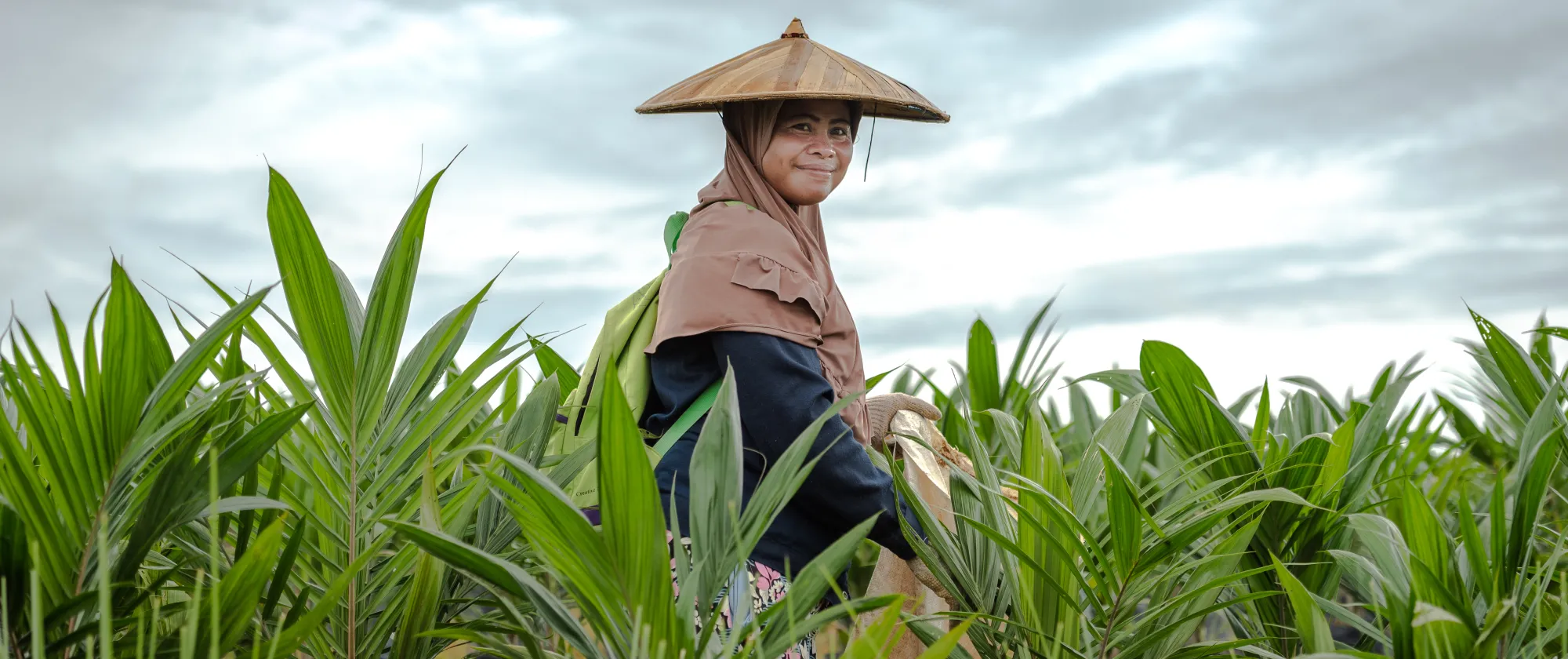 Female indonesian women in a field with a hat