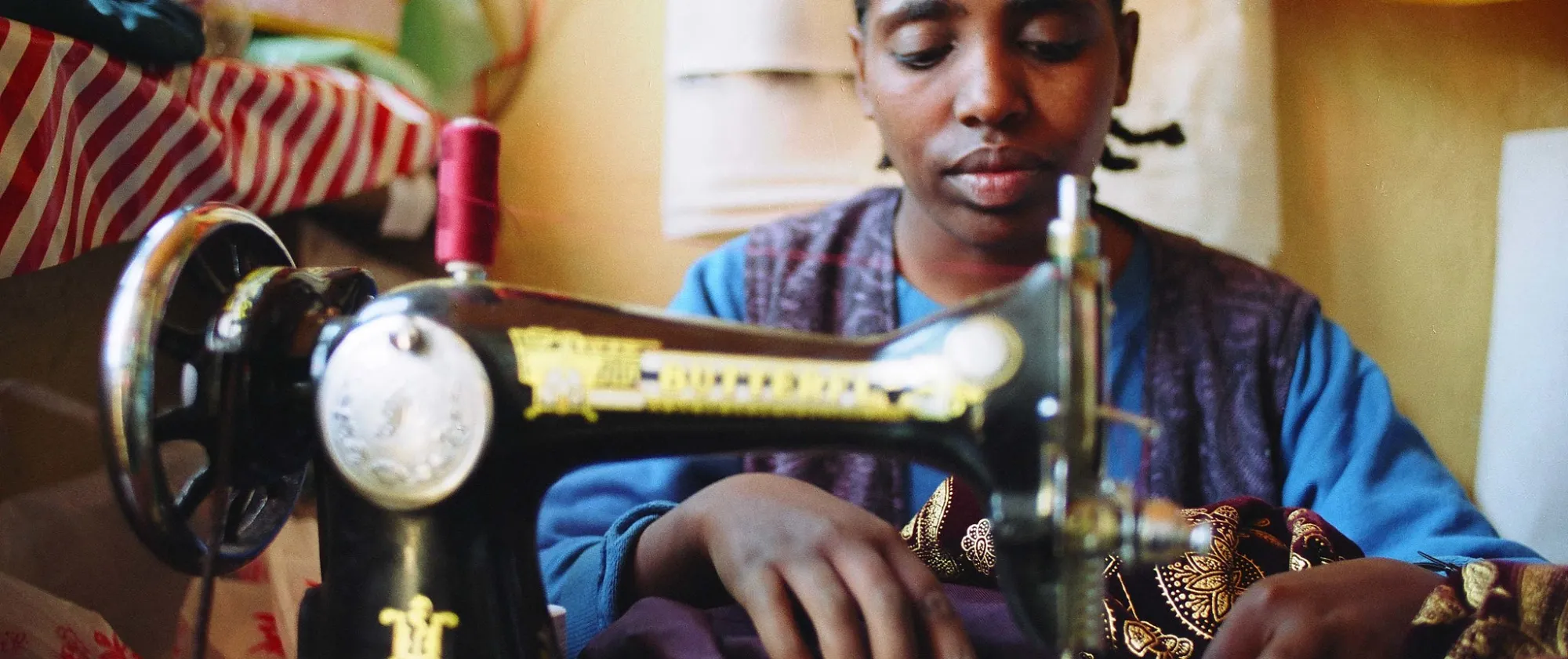 woman tailor with a hearing impairment working diligently in her shop