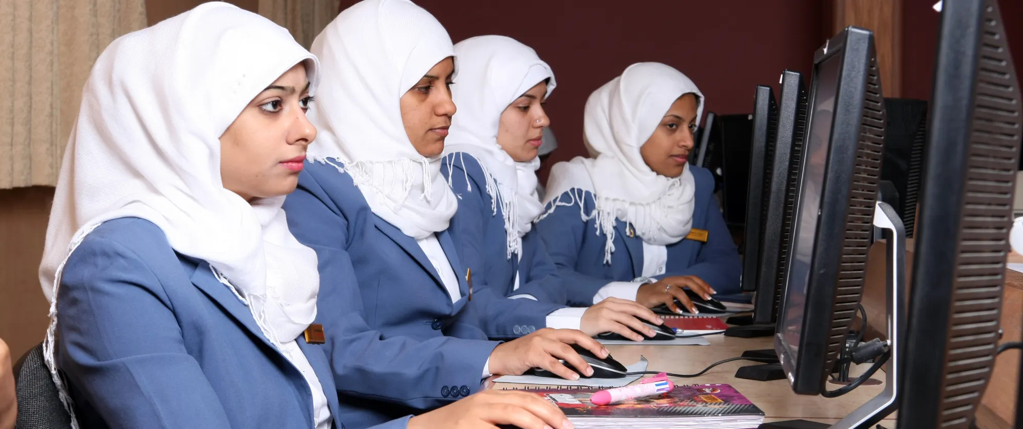 Women work on computers in a vocational training center.