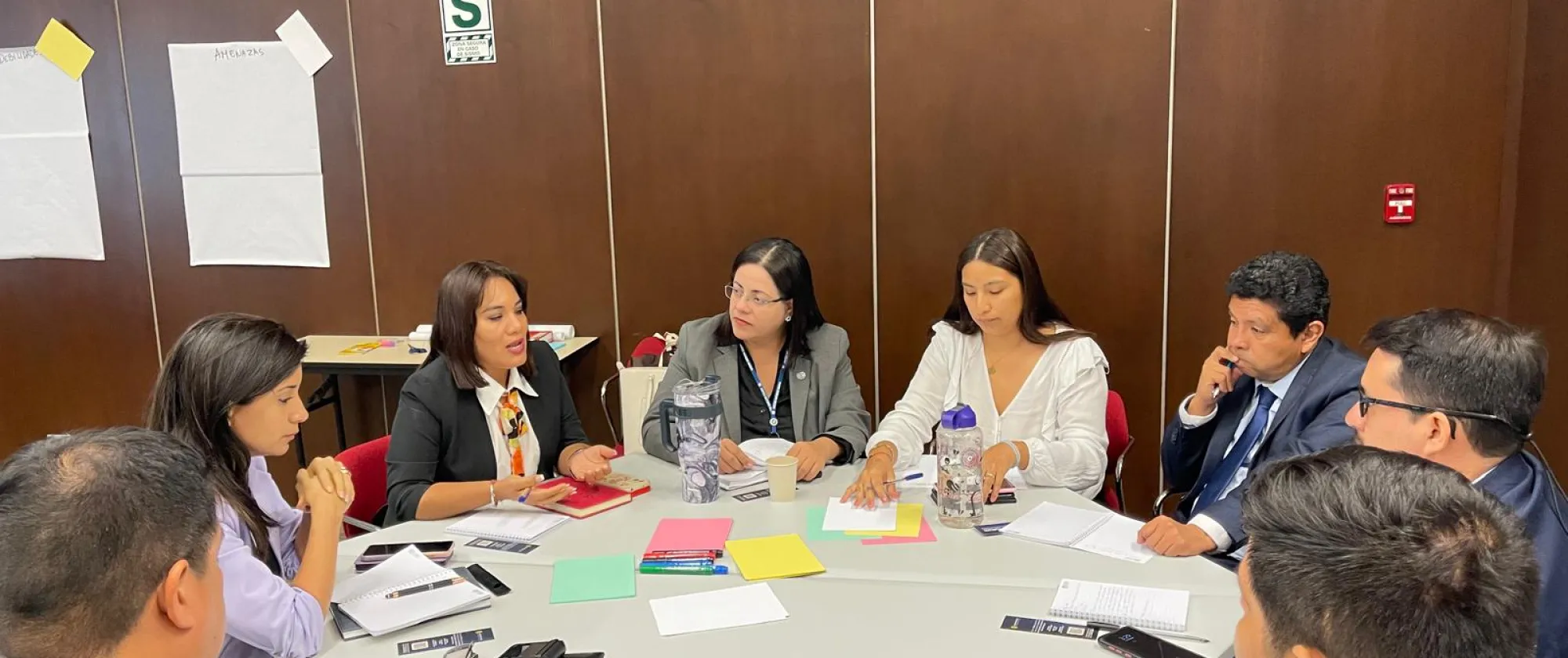 Personas sentadas en mesa redonda en trabajo de grupo