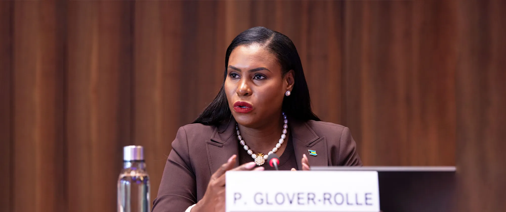 A woman sitting at a table speaking at a panel discussion
