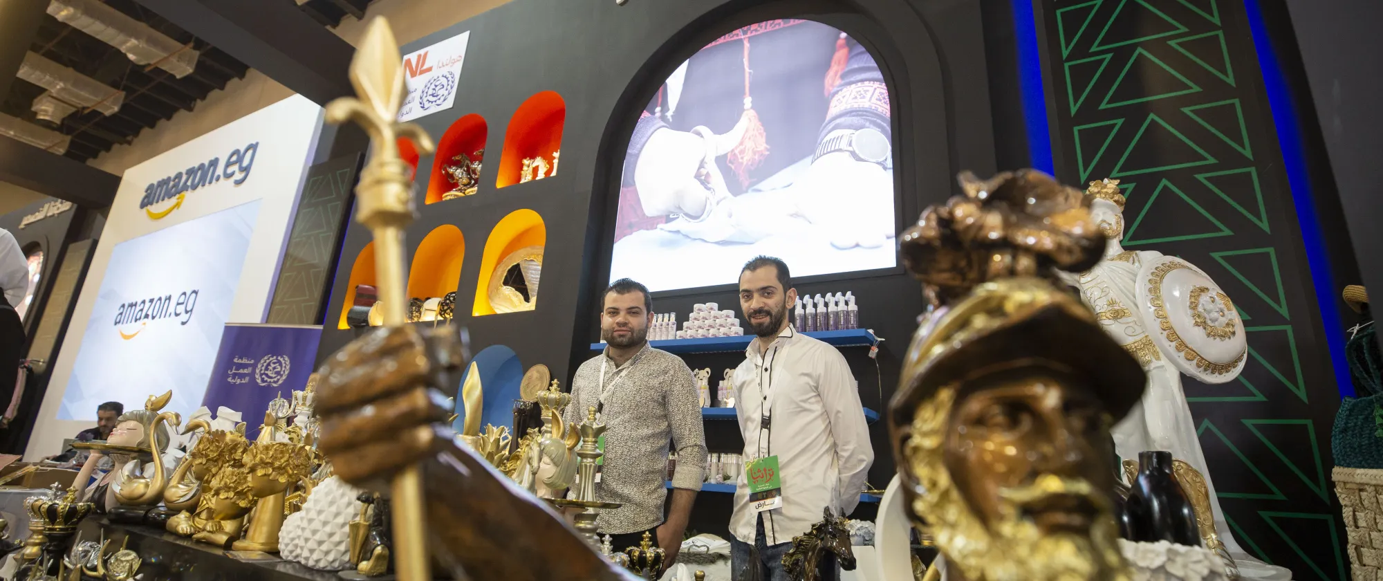 two young refugee entrepreneurs from egypt posing with their decoration products