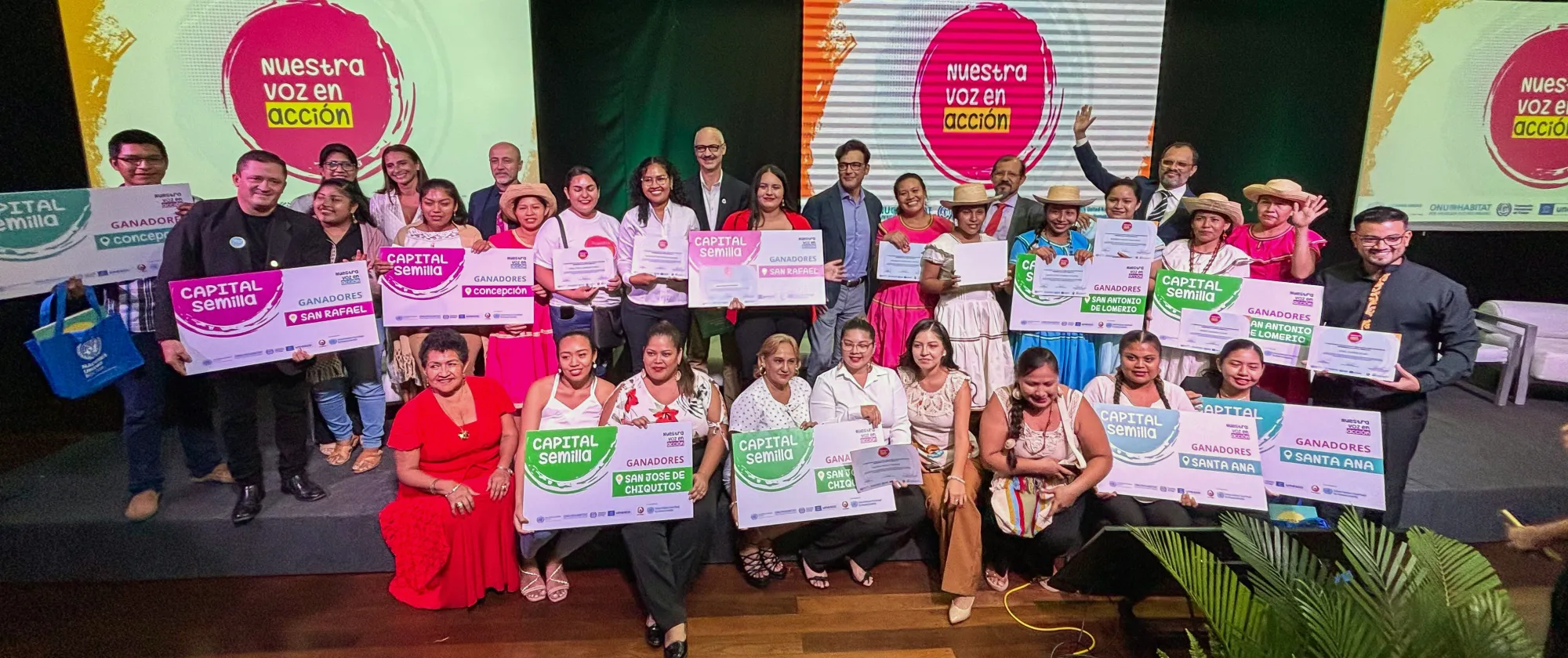 Jóvenes y autoridades del Programa Conjunto posan con carteles y levantando las manos