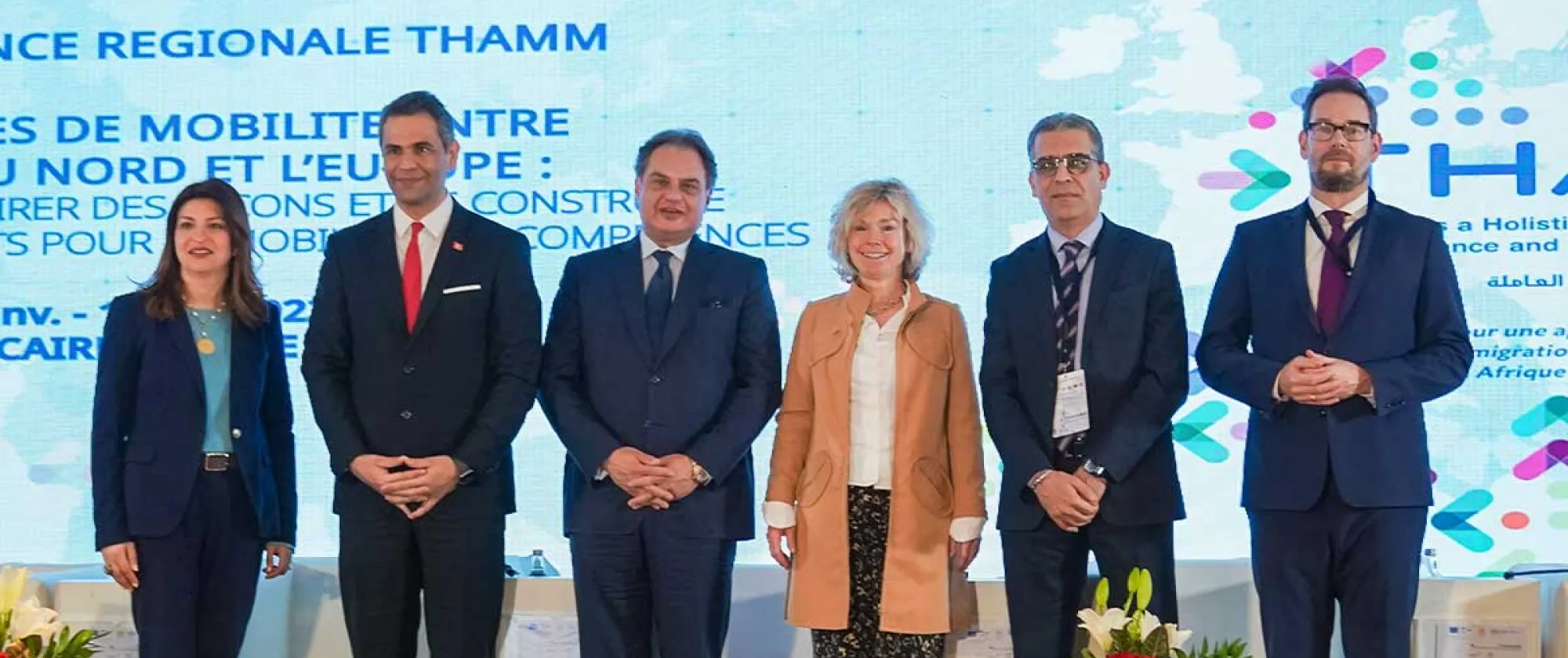 A diverse group of individuals standing together on a stage representing the opening ceremony speakers.