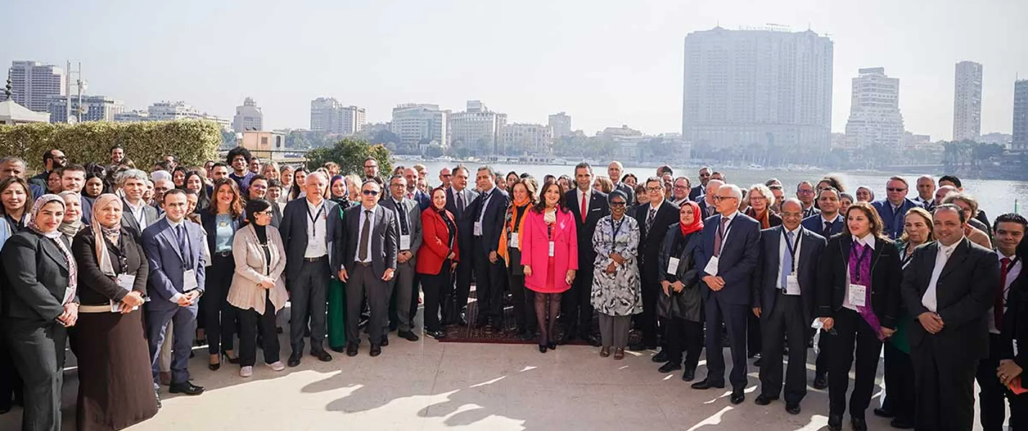 A diverse group of individuals posing in front of the Egyptian Nile river, showcasing an event group photo.