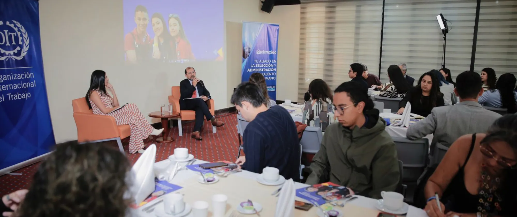 Ángela Herrera, punto focal de juventudes e Italo Cardona, director de la OIT para los Países Andinos hablando en plenaria frente a jóvenes invitados