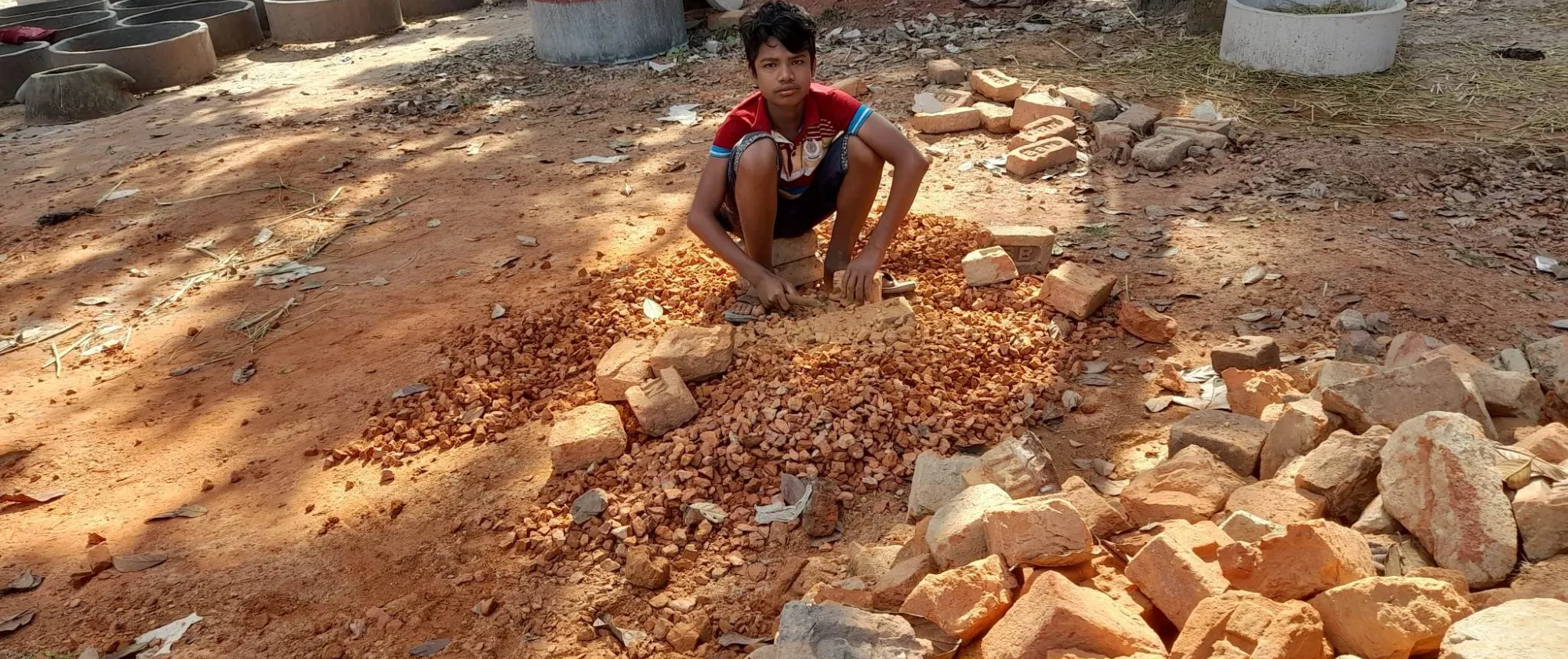 A child working at a quarry breaking stones 