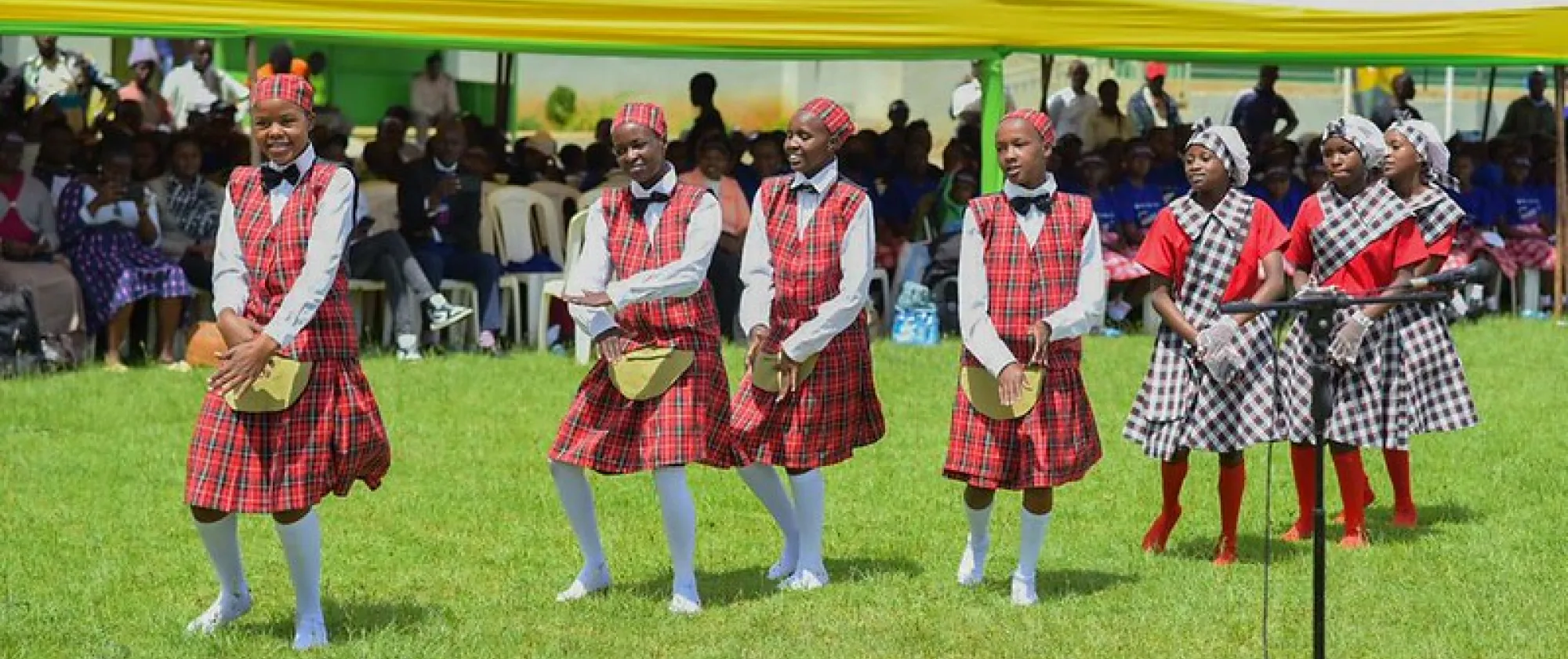 Children in red uniform do a dance performance during the world day against child labour commemoration ceremony