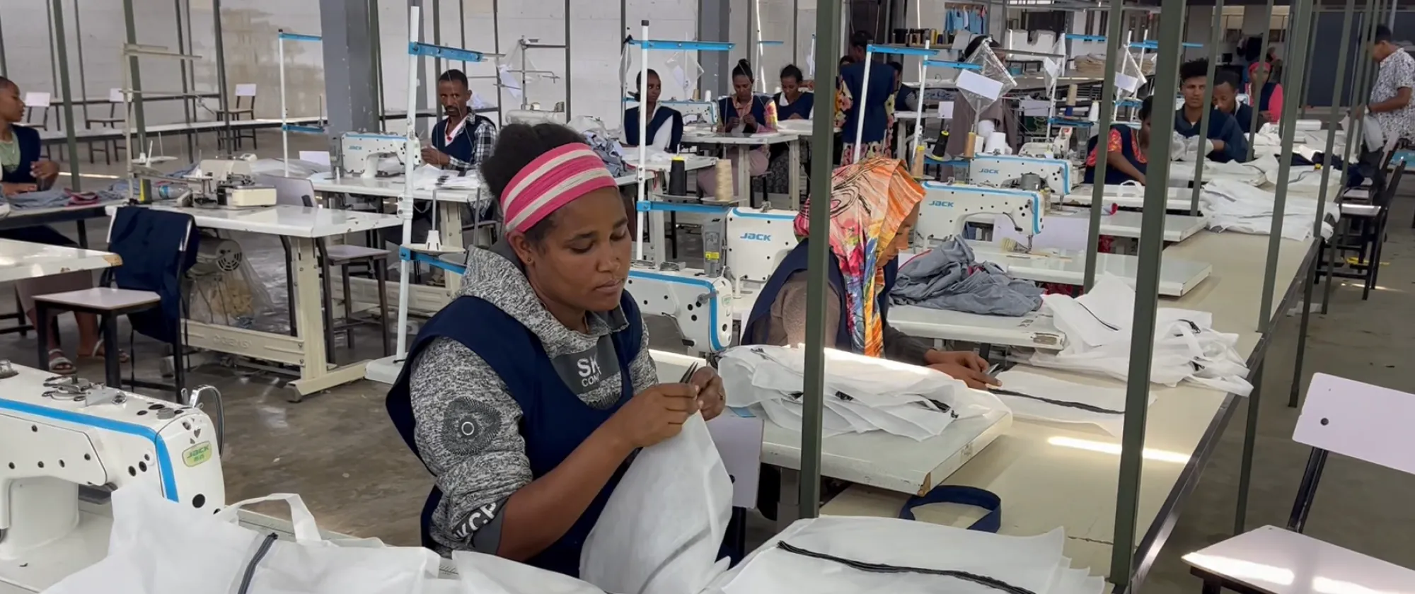 A women doing her trimming job in a garment factory.
