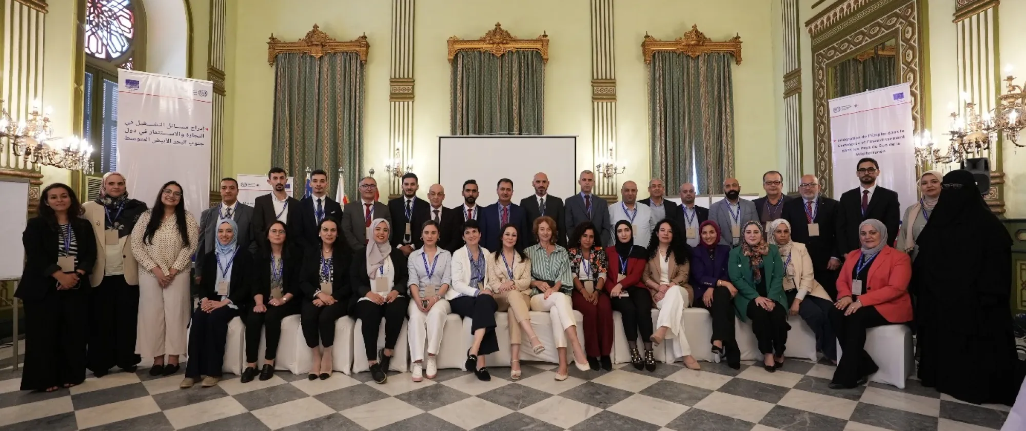 A diverse group of individuals gathered in a room seated closely together.