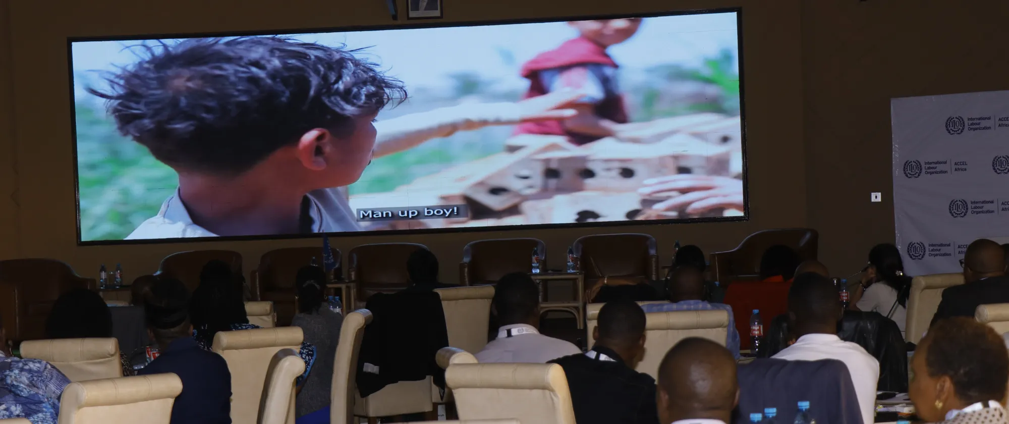 A movie is shown in a big screen in a meeting room