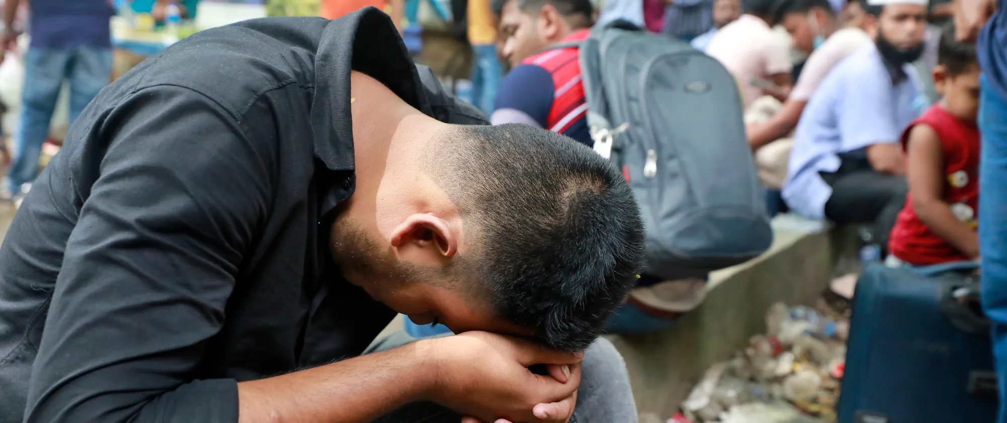 A disappointed Bangladeshi migrant worker slouches after failing to get an air tickets to return to Saudi Arabia to resume work