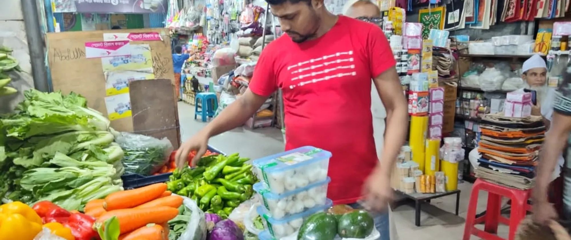 A trader at a market in Dhaka, Bangladesh arranges vegetables