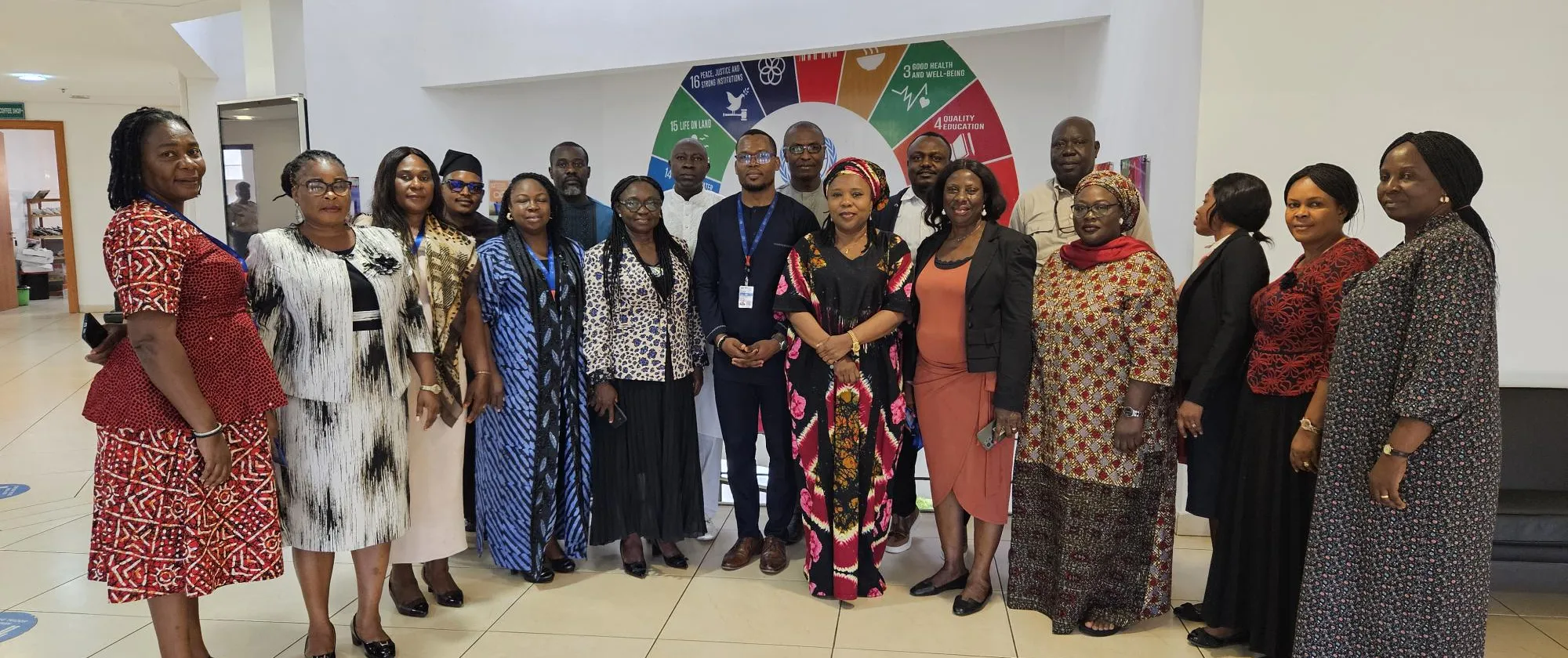 Stakeholders post in front of a UN SDGs banner