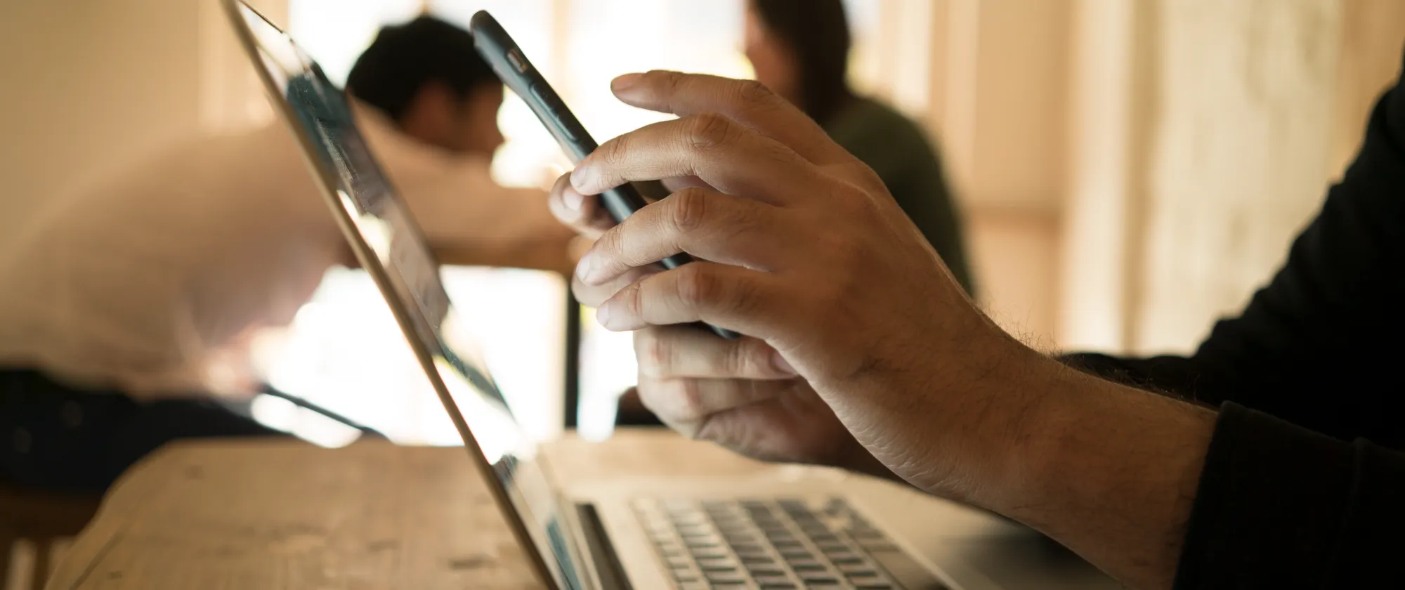 Person sitting with their laptop and phone