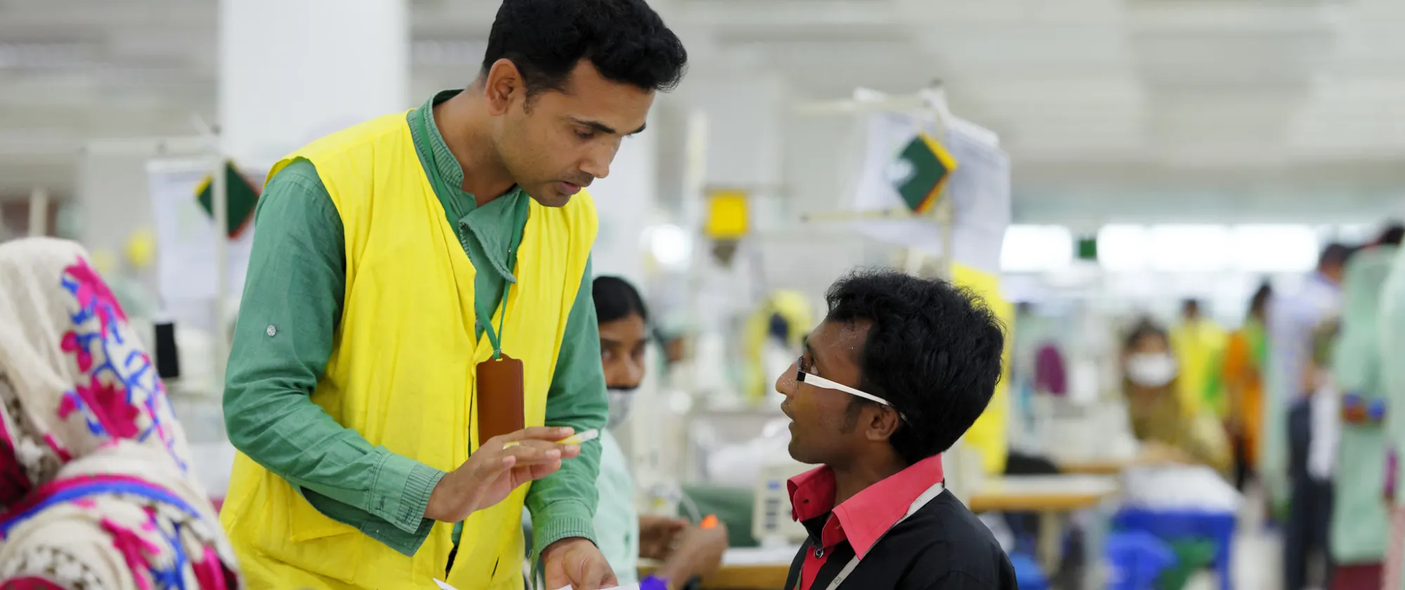 Empleados de una fábrica de ropa discuten los procedimientos de producción en una planta de Bangladesh.
