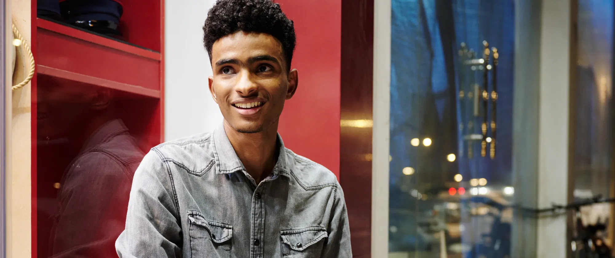 a young man sitting on stairs in the street with a smile on ghis face