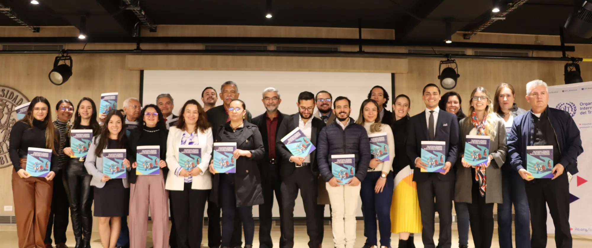 Foto grupal de los participantes del evento sosteniendo la cartilla.