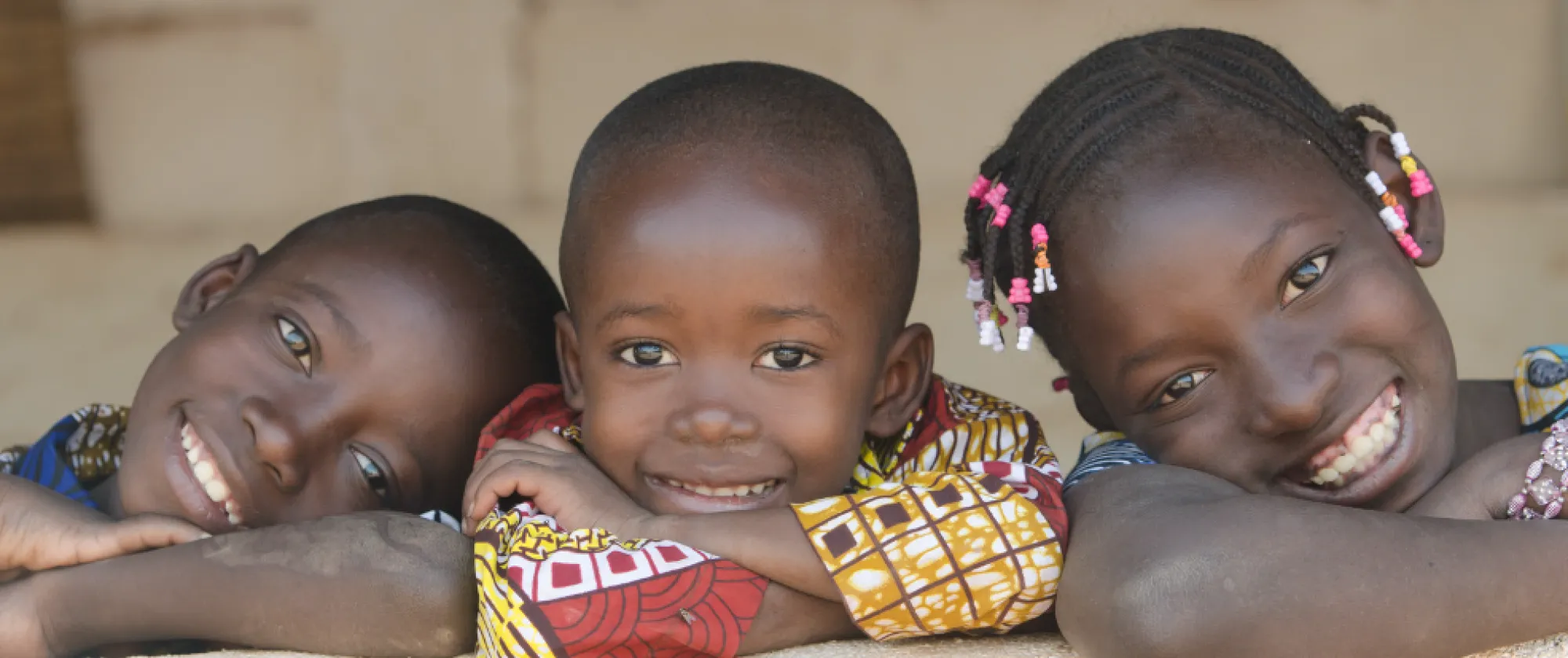 two boys and a girl smile to the camera