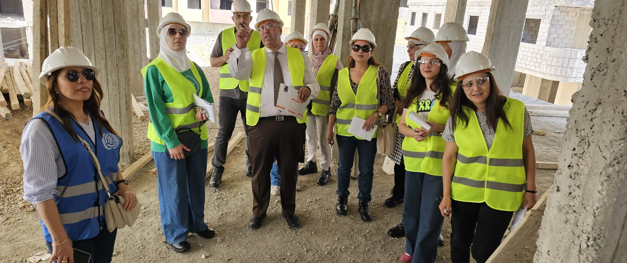 a group of men an women in a field visit to a construction site