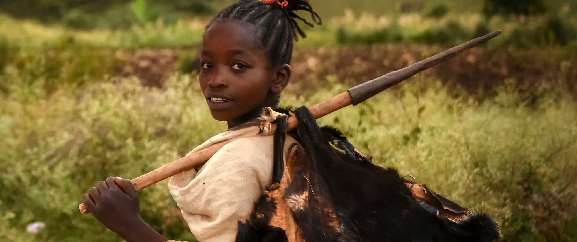 Young African girl carrying a load on her back in Ethiopia