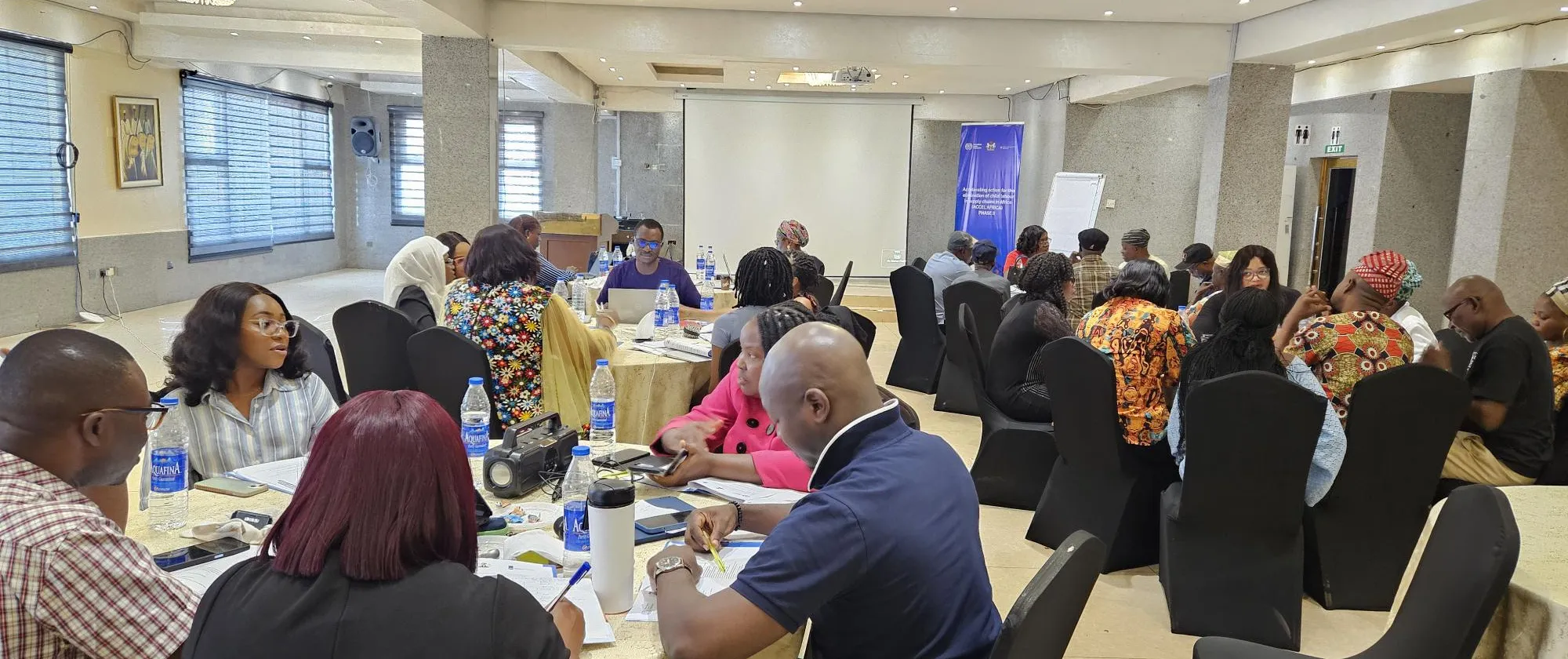 Participants to a workshop seat in a meeting room and write in their notebooks