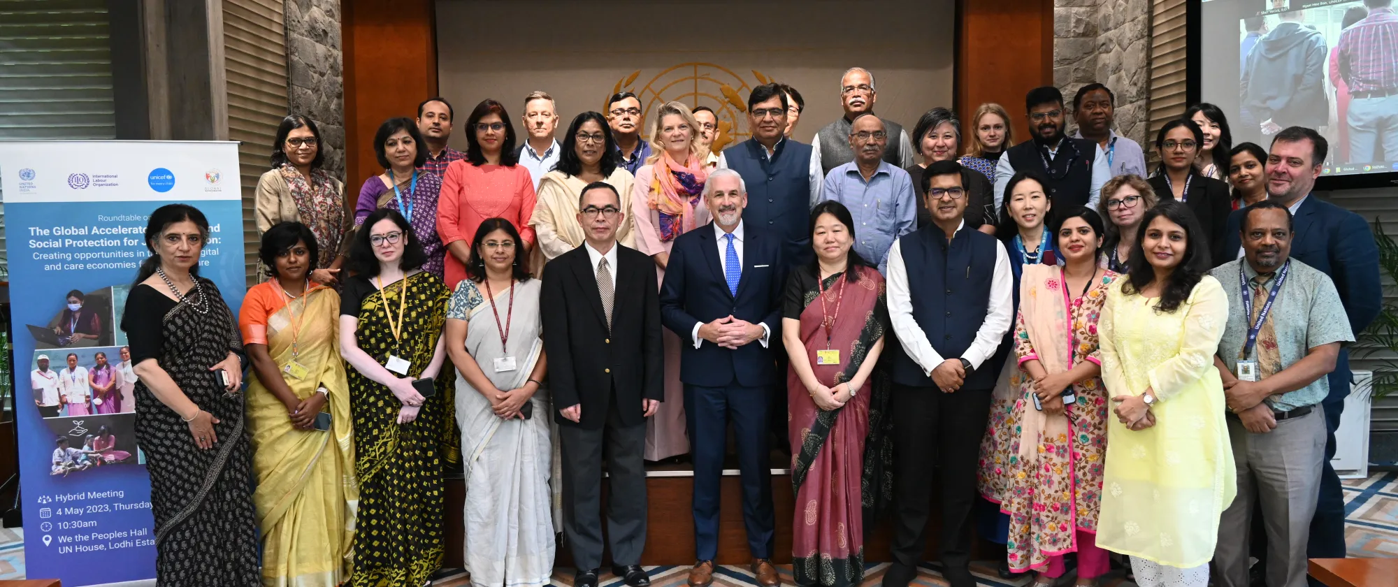 Participants from the event standing in three rows in a conference room