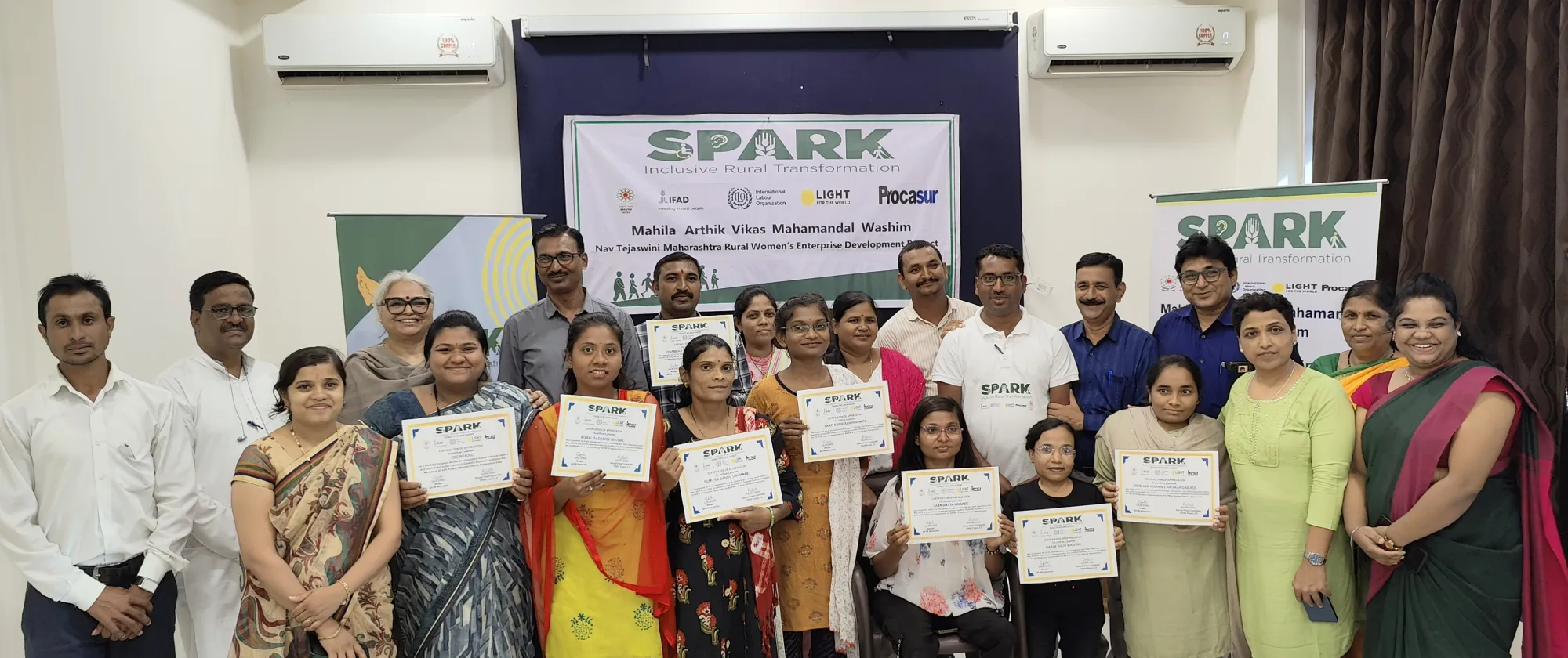 People holding up certificates at the end of the certification ceremony