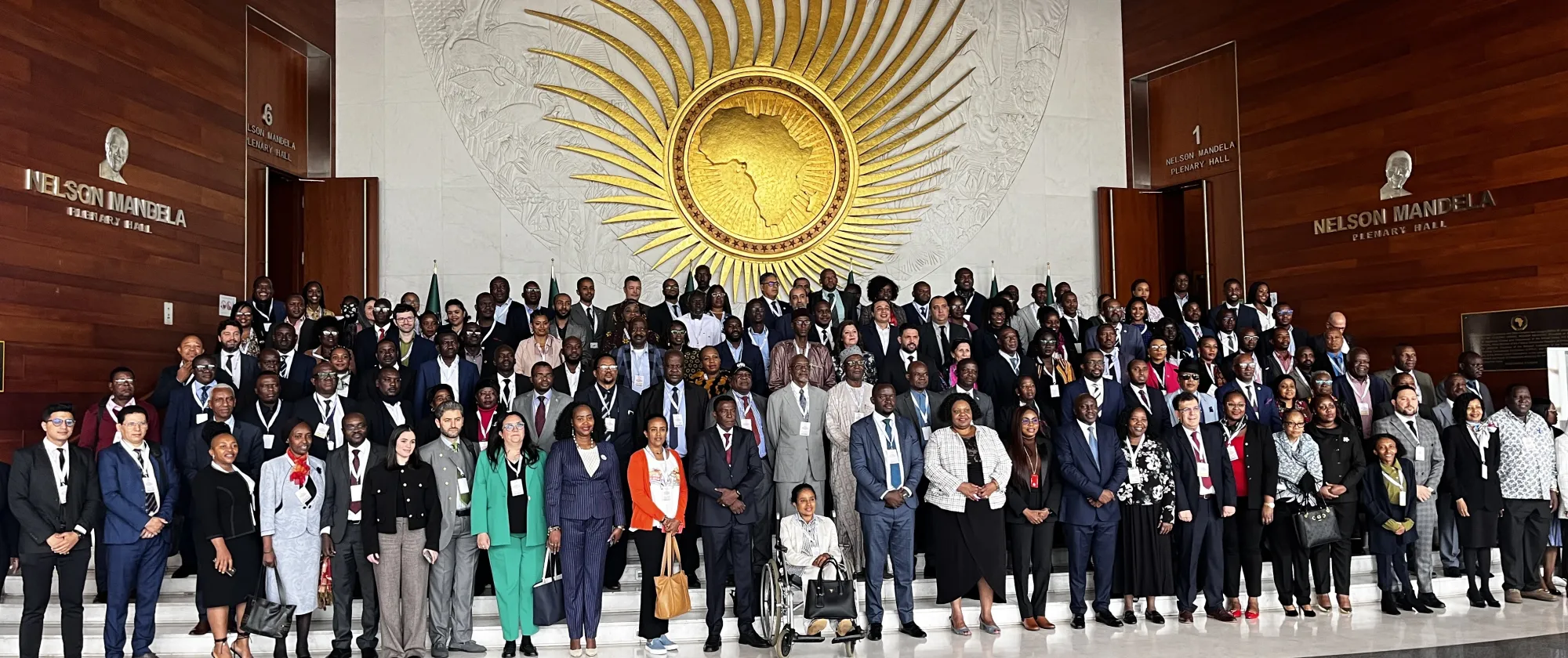 Delegates stand in a hall inside the African Union building and sign for a group picture