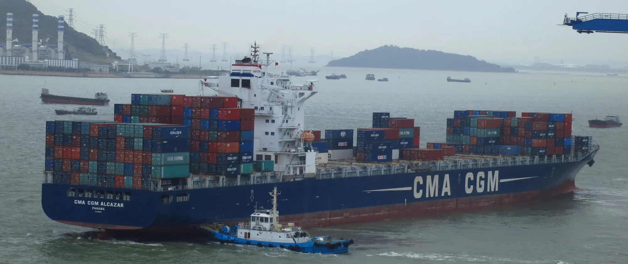 A tug pushes a cargo ship exiting the Port of Chiwan, in Guangdong province, China.