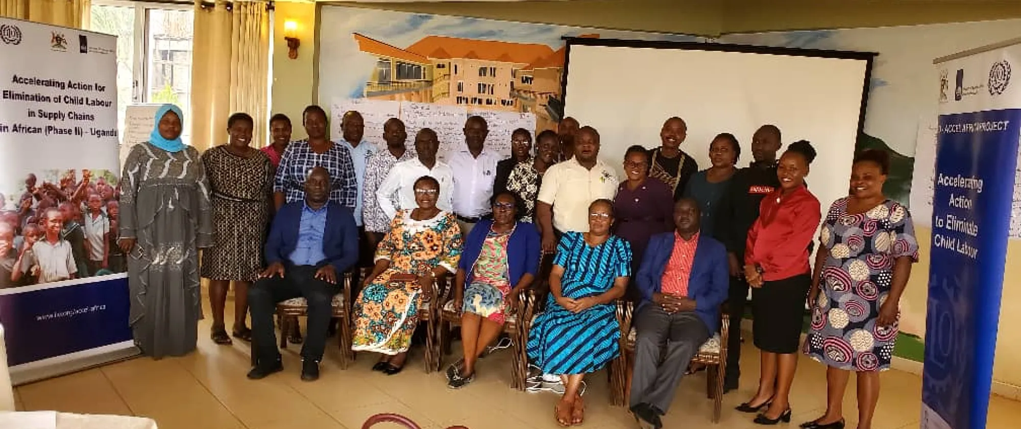 Participants to the meeting take a group picture with two project banners
