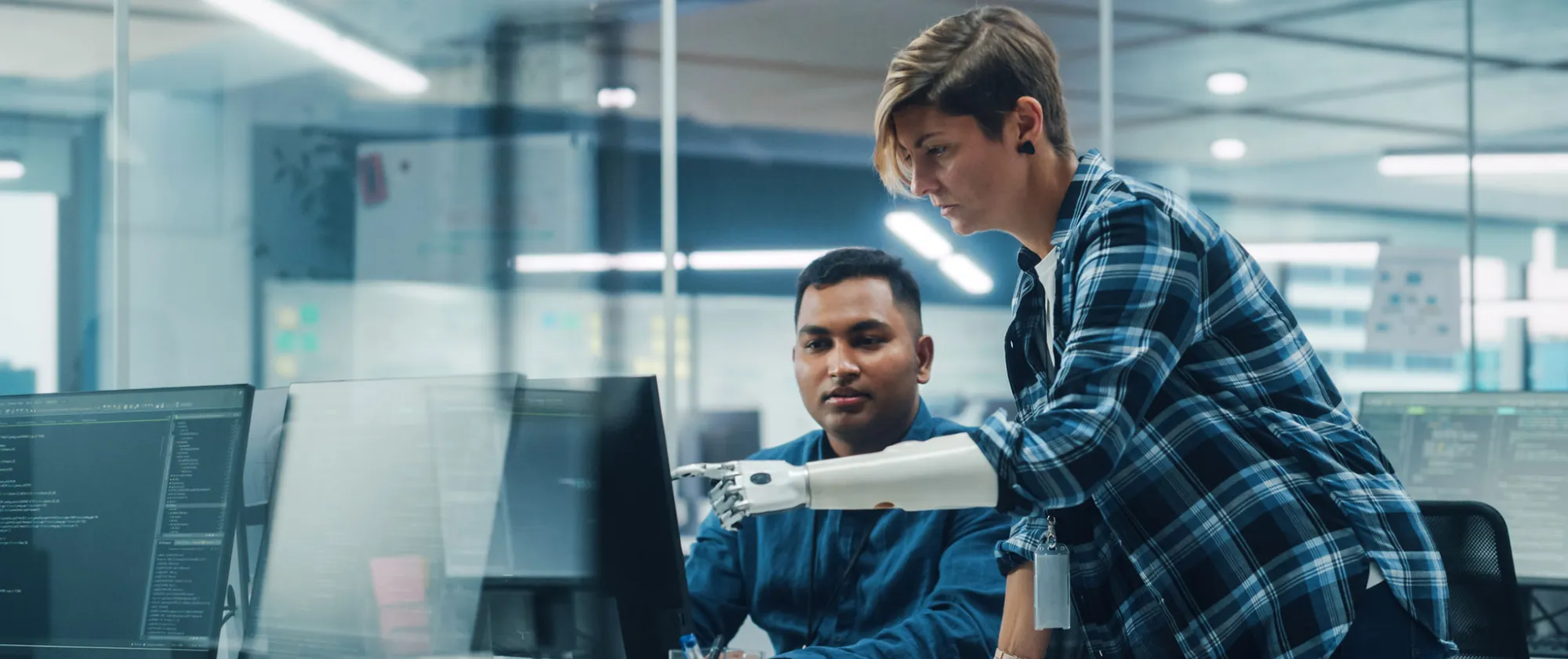 Woman with disability working on computer with prosthetic arm