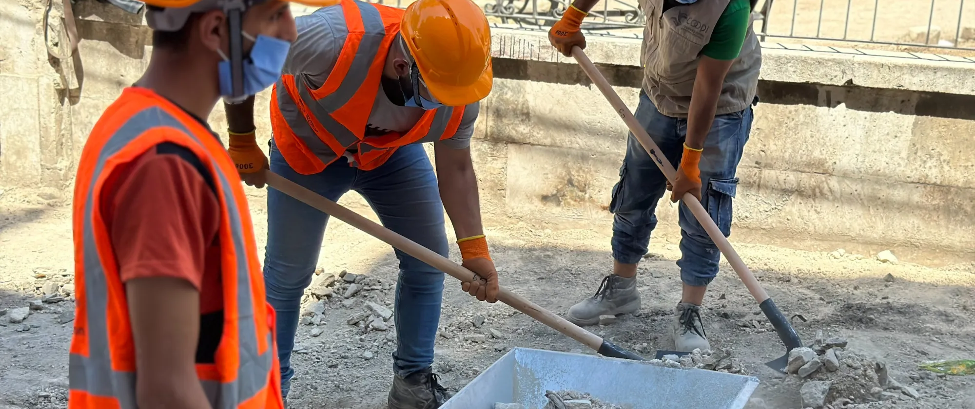 Community workers rehabilitating sidewalks surrounding a public park in Kadi Askar for a safer communal space