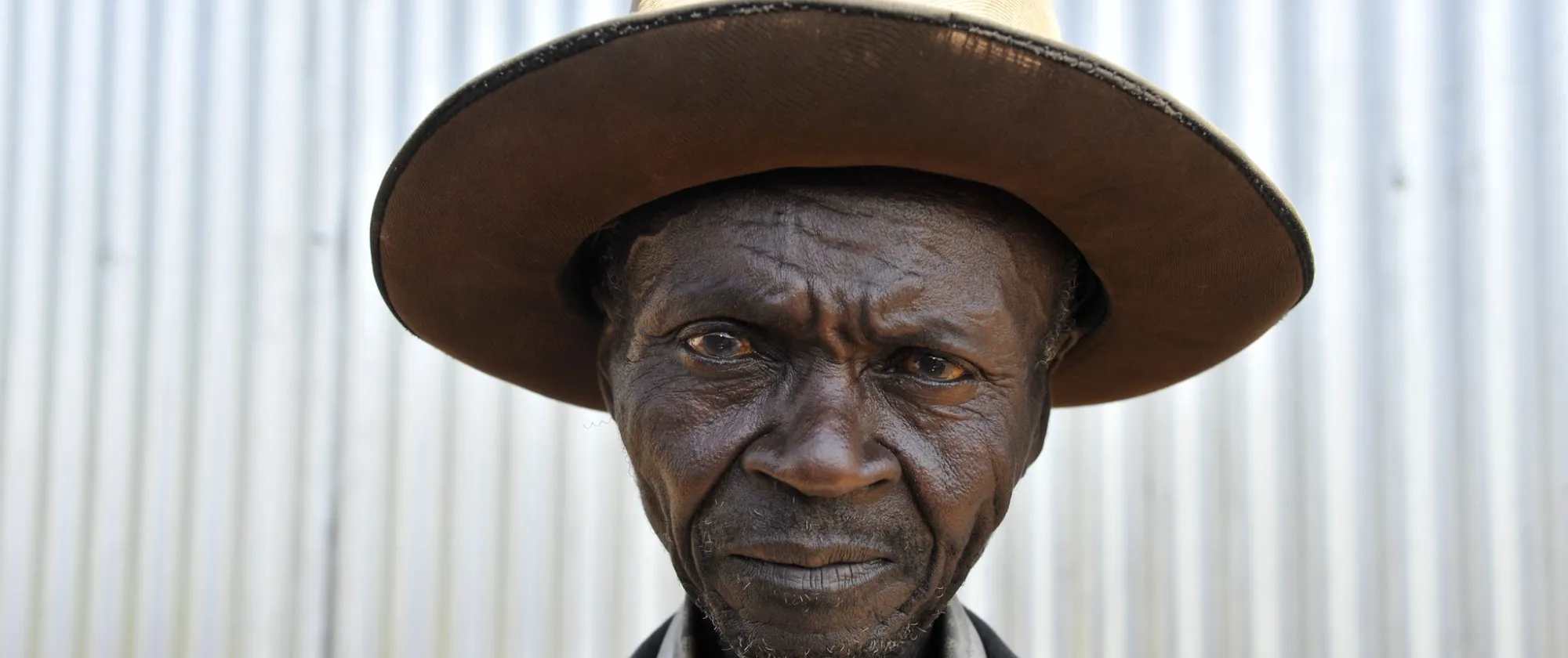 street portrait of an old man in the no man's land near the Busia border, from Kenya to Uganda