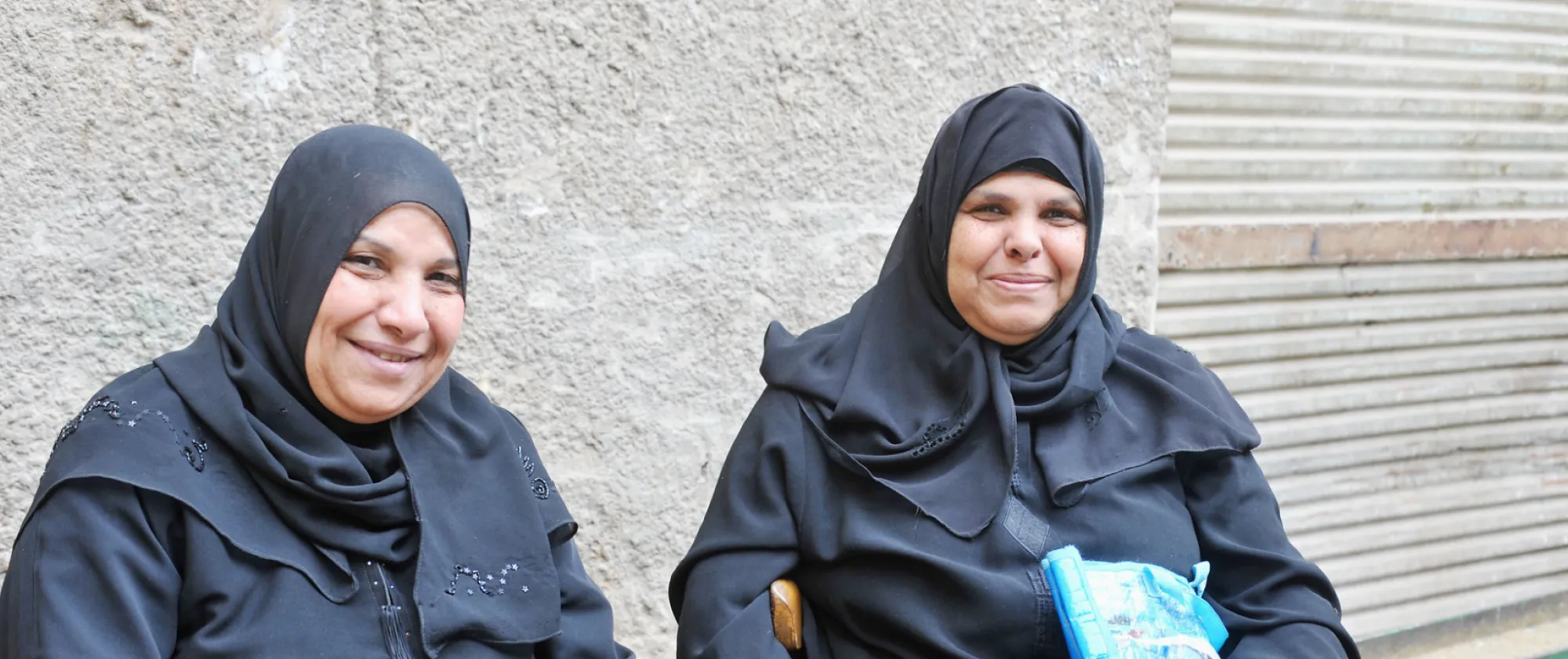 Two women sit outside in Bab el Foutouh District. Cairo, Egypt.