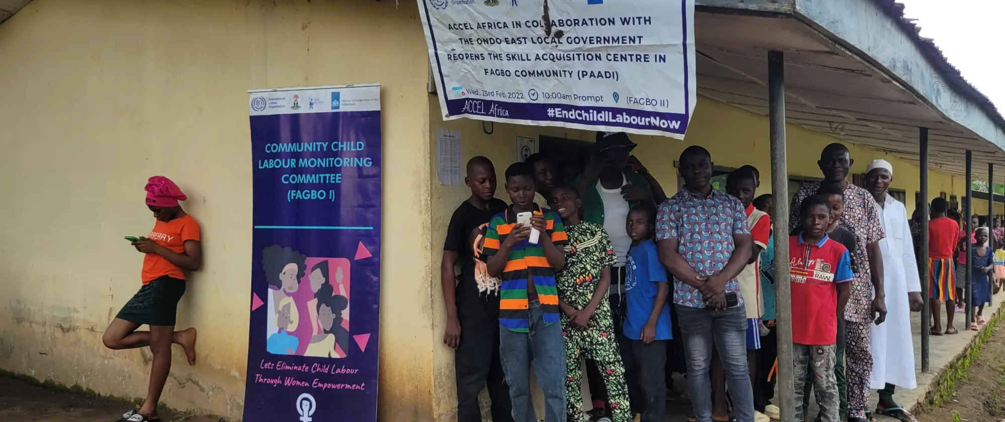 Students and teachers stand outside the classrooms of the skills acquisition center