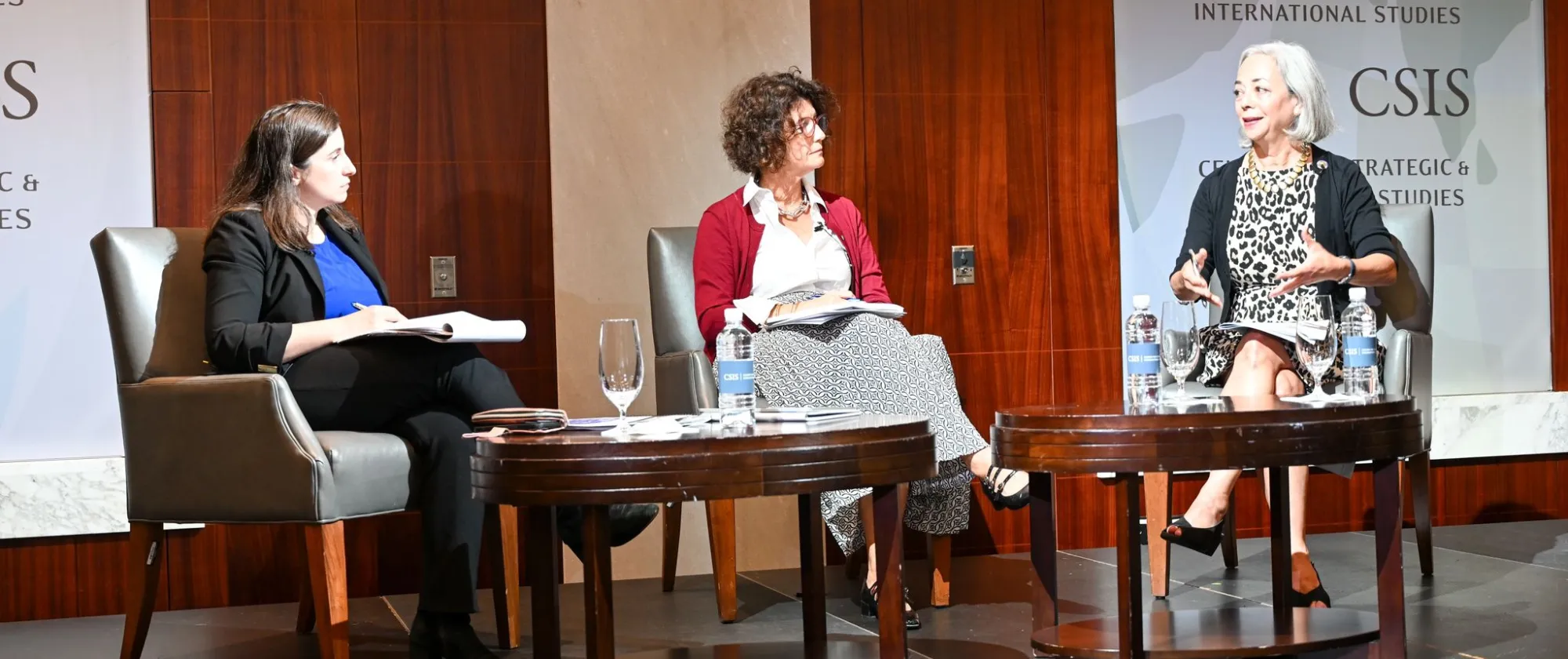Three women sitting on a stage discussing