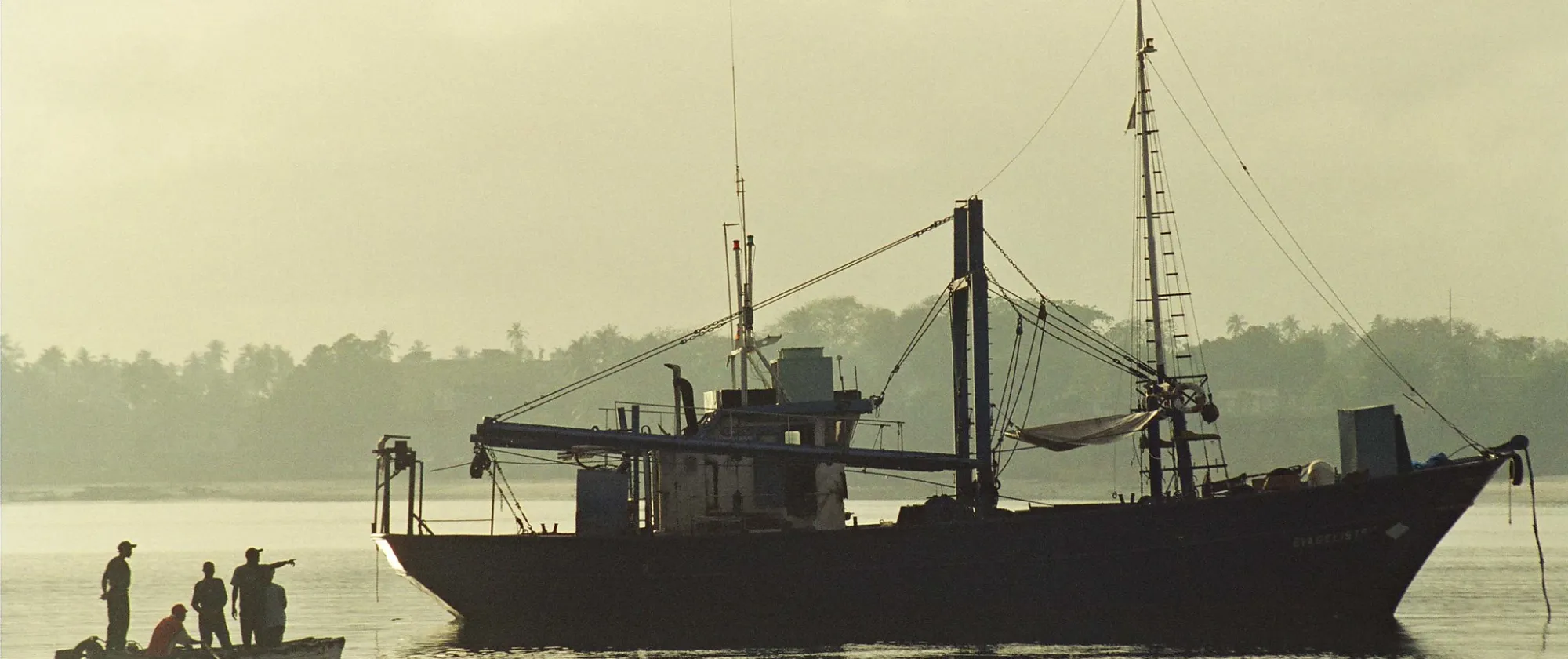 A serene boat floating gently on calm waters, reflecting the surrounding landscape.