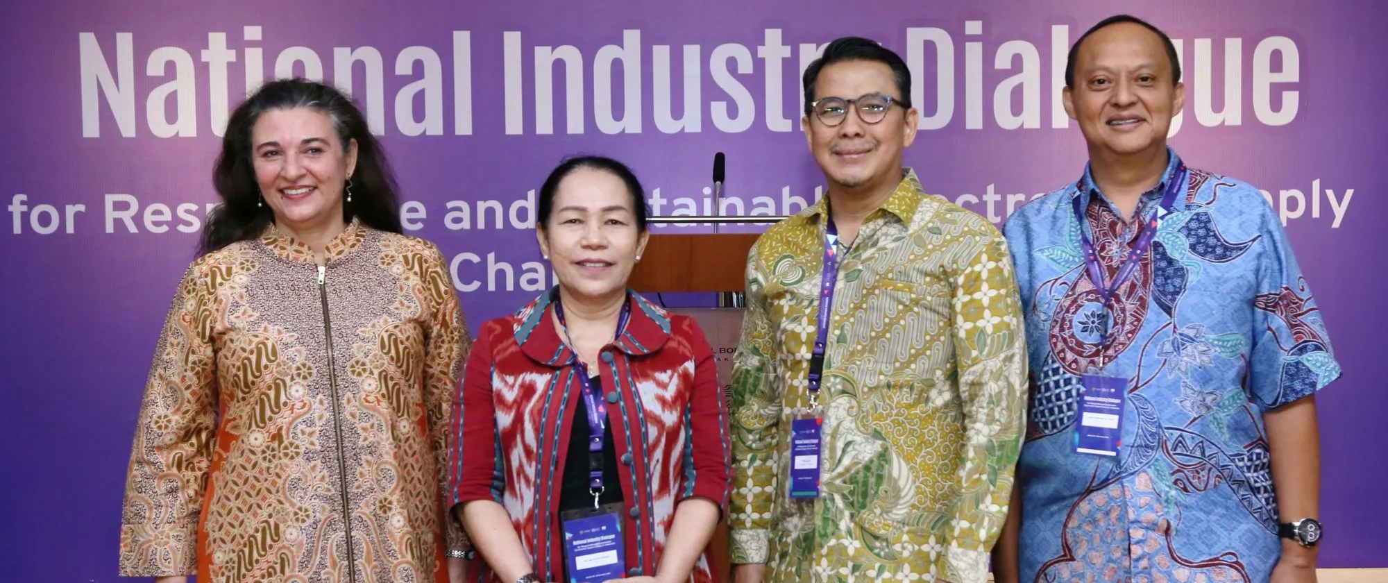 Four representatives of the ILO, trade union, Coordinating Ministry for Economic Affairs and Ministry of Manpower standing on the stage.
