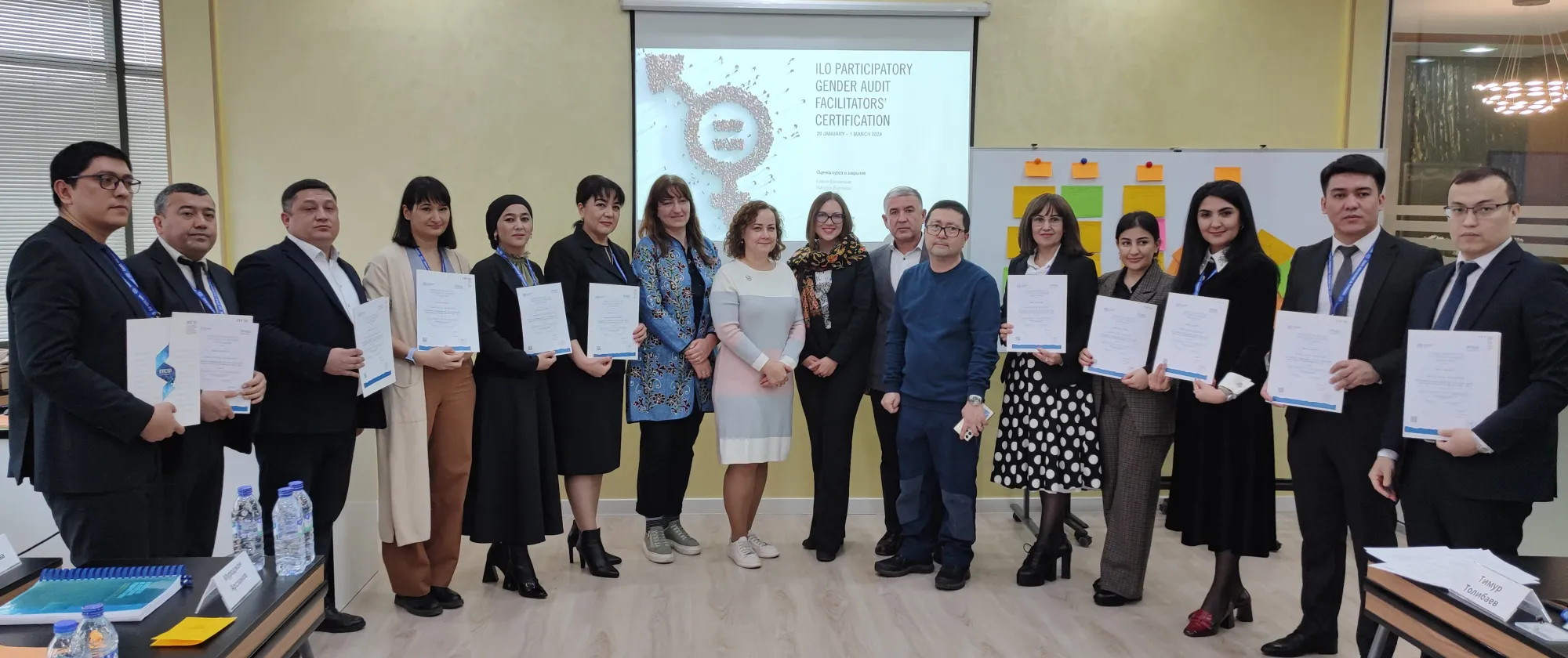 Uzbekistan Trade Unions representatives stand holding certificates of the ILO Participatory Gender Audit Facilitators Certification Course