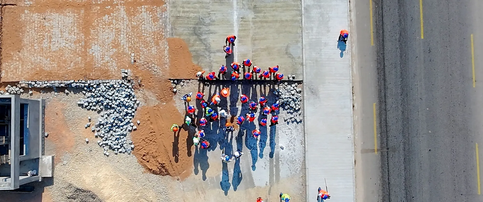 A drone shot of journalists visiting a road construction site in northern Madagascar, seen from above with the road beside them.